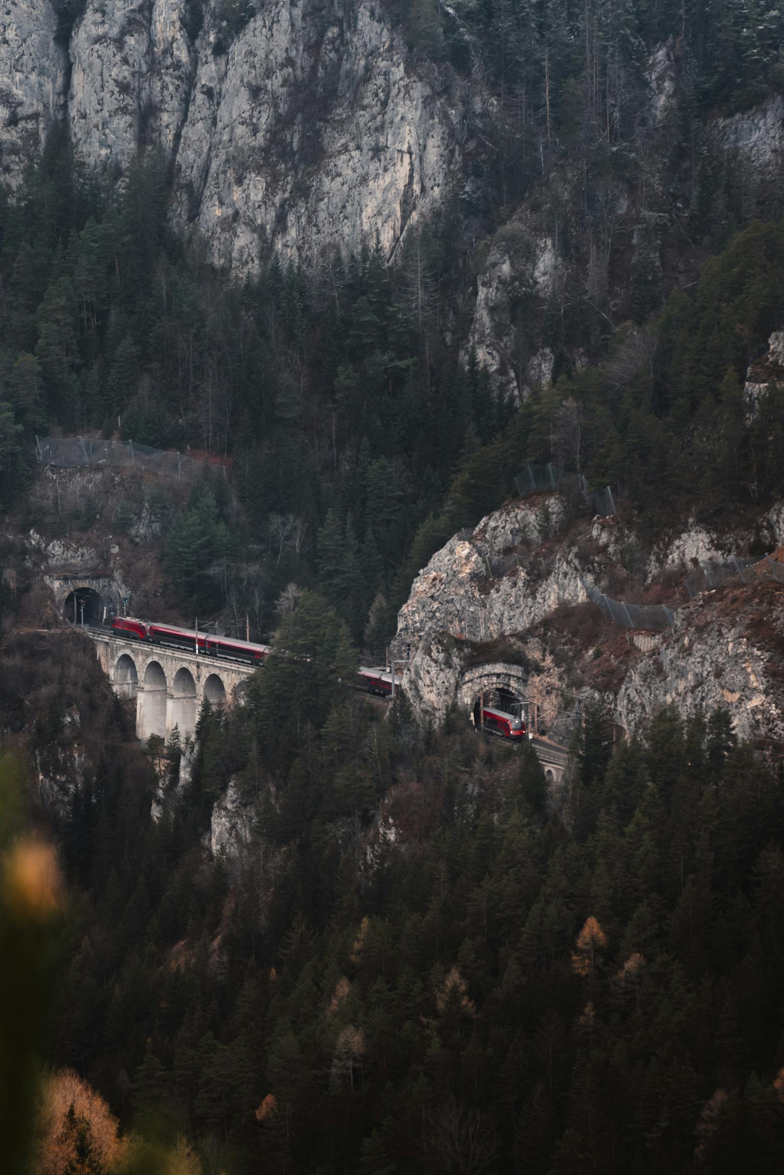 A picturesque view of a train crossing the historic Semmering railway in Austria's mountainous landscape.