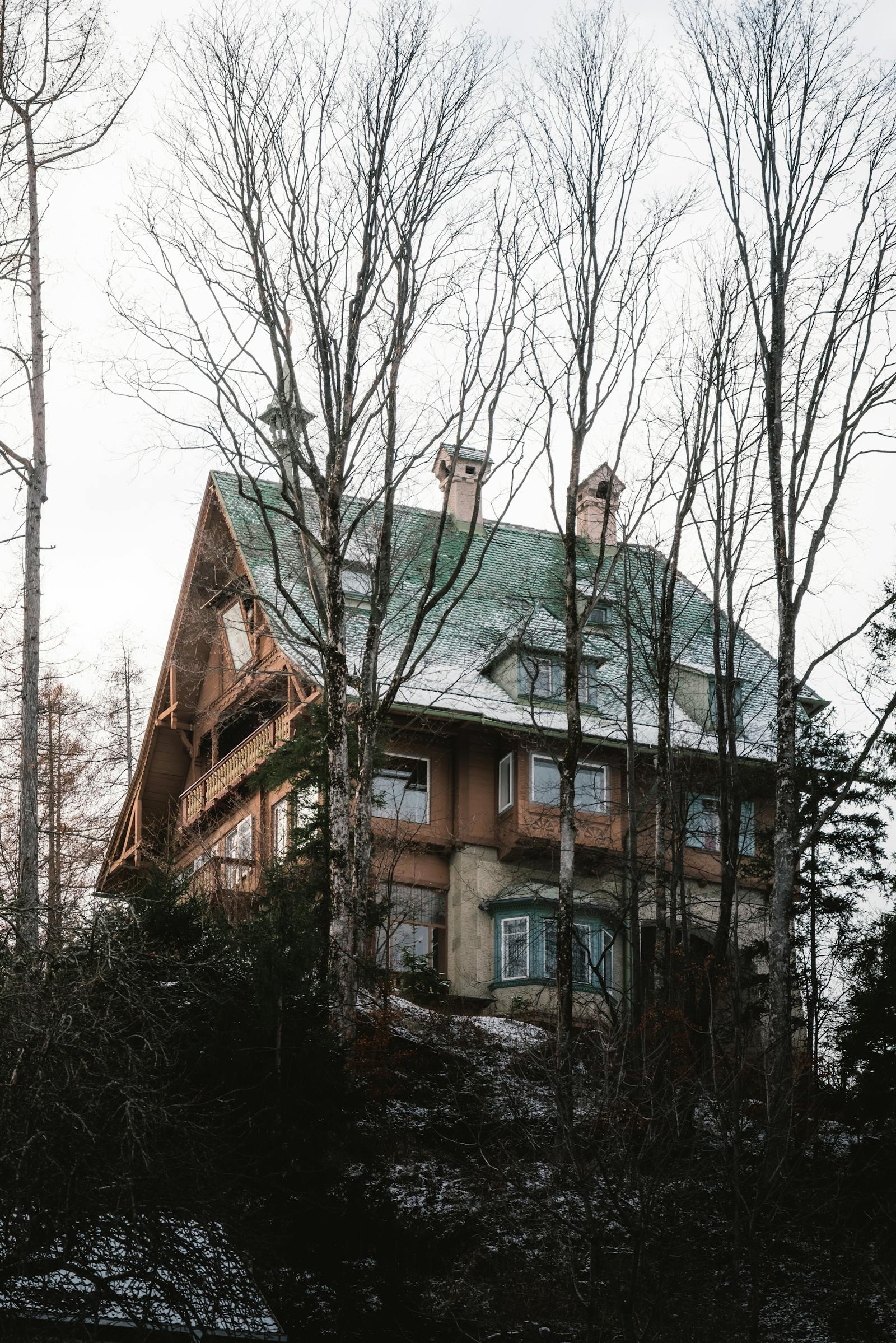 Scenic winter view of a rustic cabin surrounded by a serene forest in Styria, Austria.