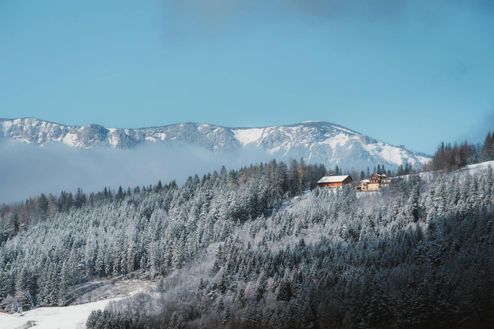 Captivating winter scene of snow-covered mountains and forest in Styria, Austria.