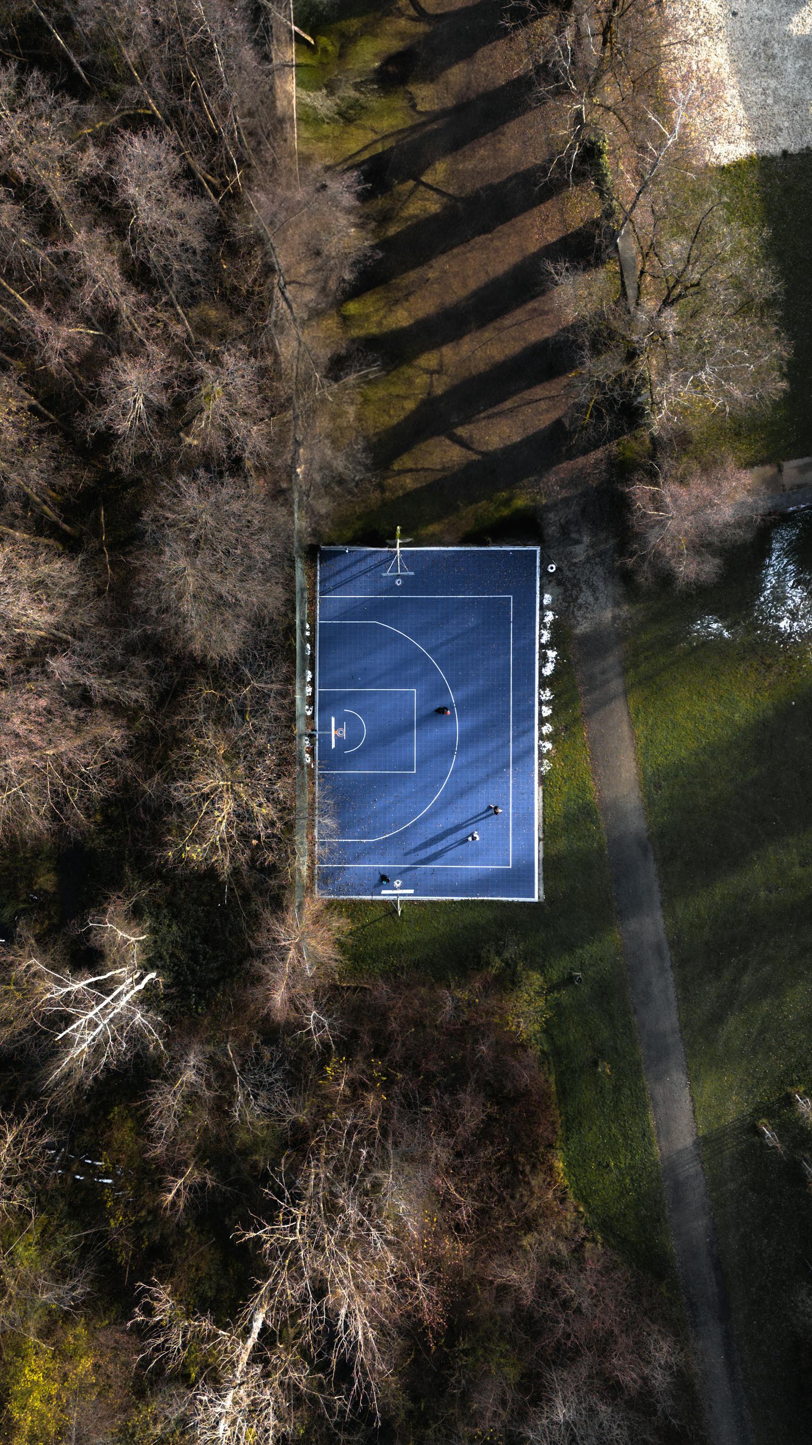 A unique aerial shot of a basketball court surrounded by trees in Graz, Austria.