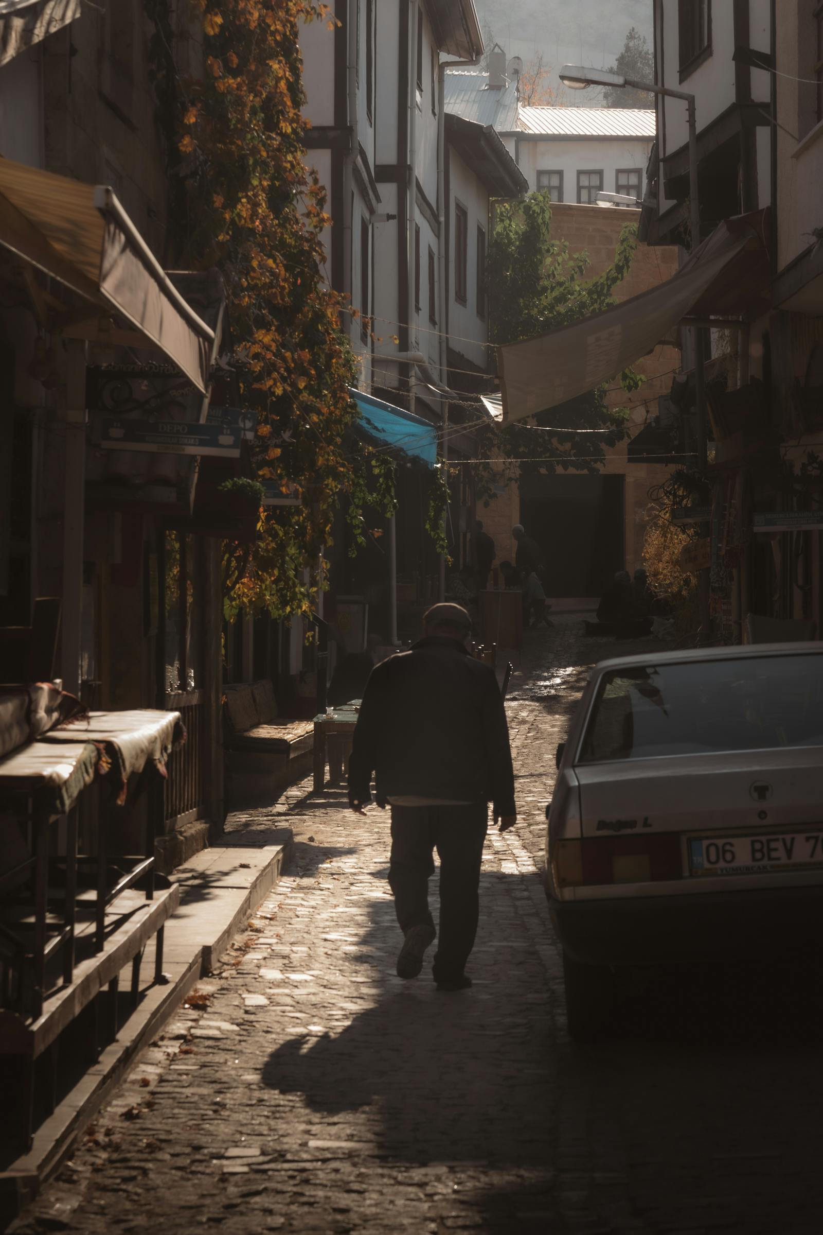 Atmospheric morning view of a person walking in a historic Beypazarı alley in Ankara, Türkiye.