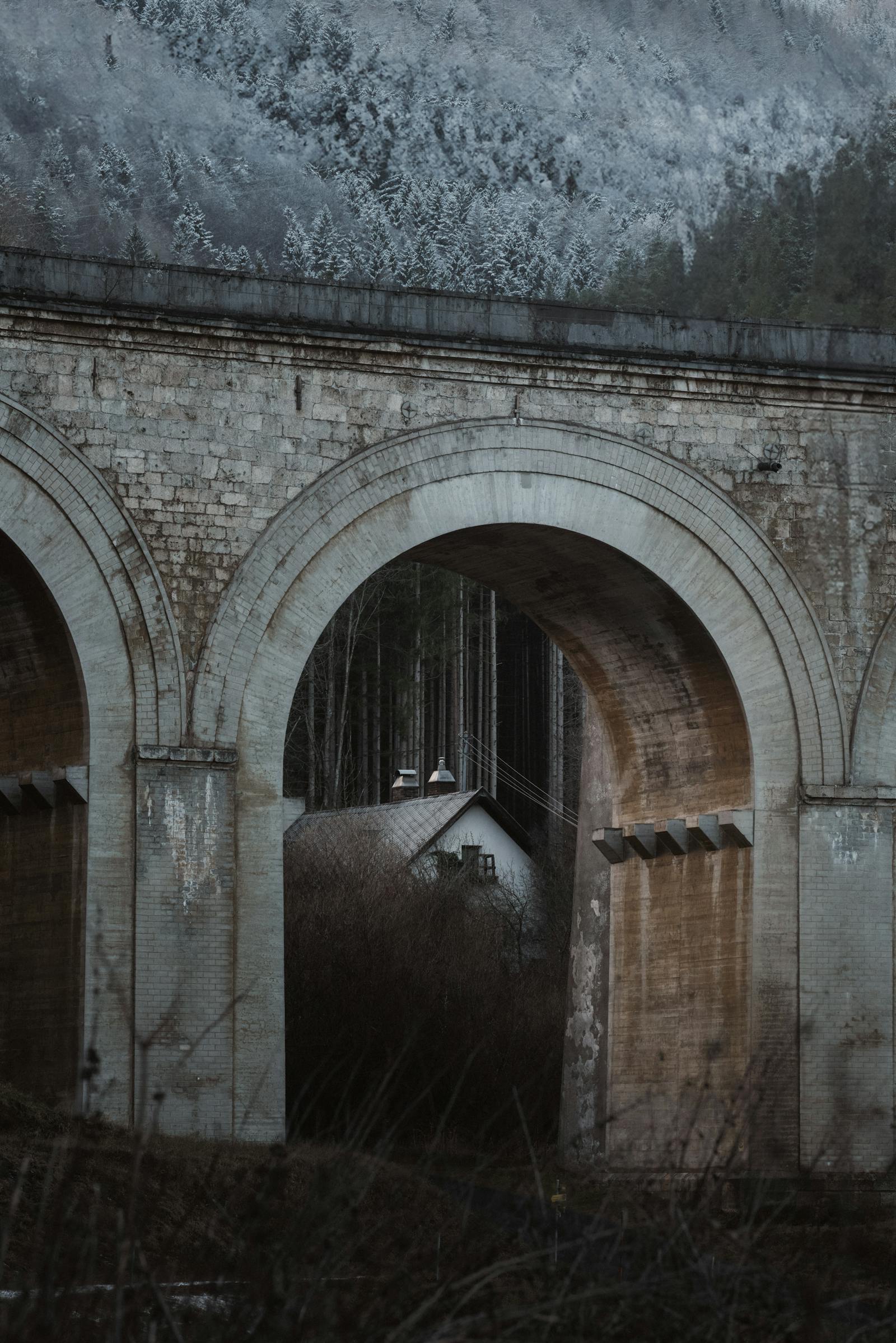 A picturesque stone arch bridge in Semmering, Austria, with a forest backdrop.