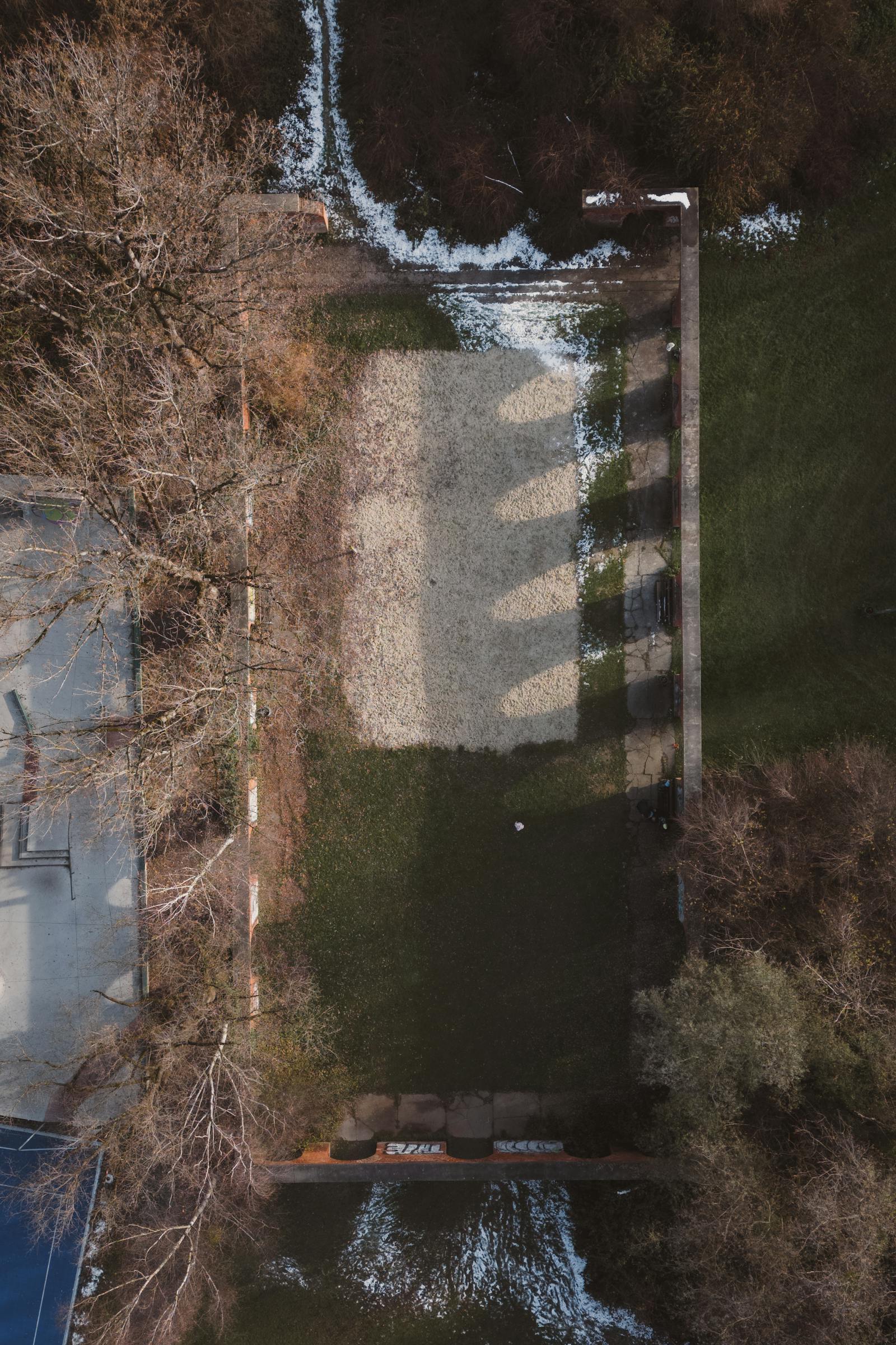 Aerial perspective of a deserted yard with patches of snow and shadows in Graz, Austria.