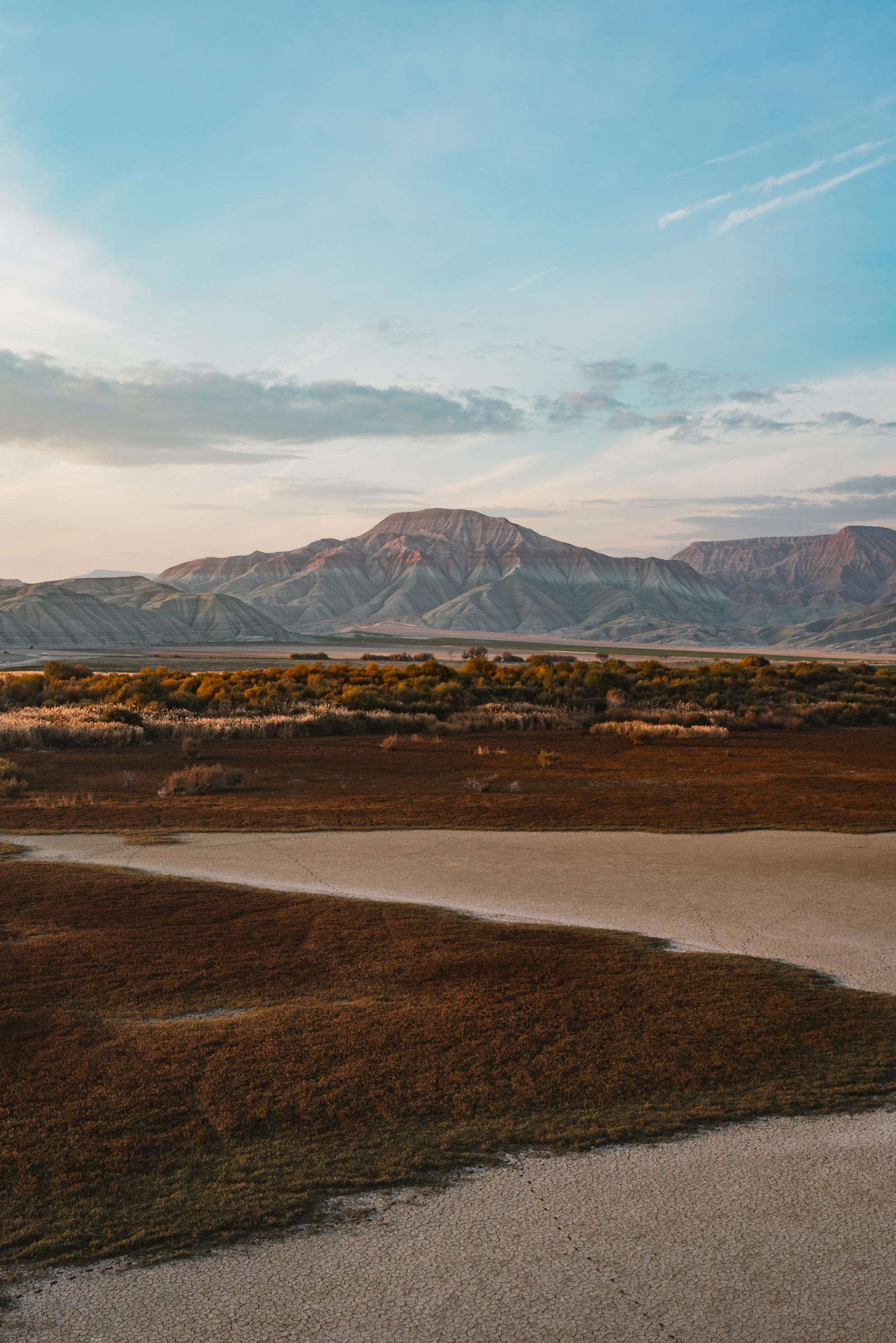 Peaceful landscape with mountains and vibrant skies at sunset, ideal for backgrounds.