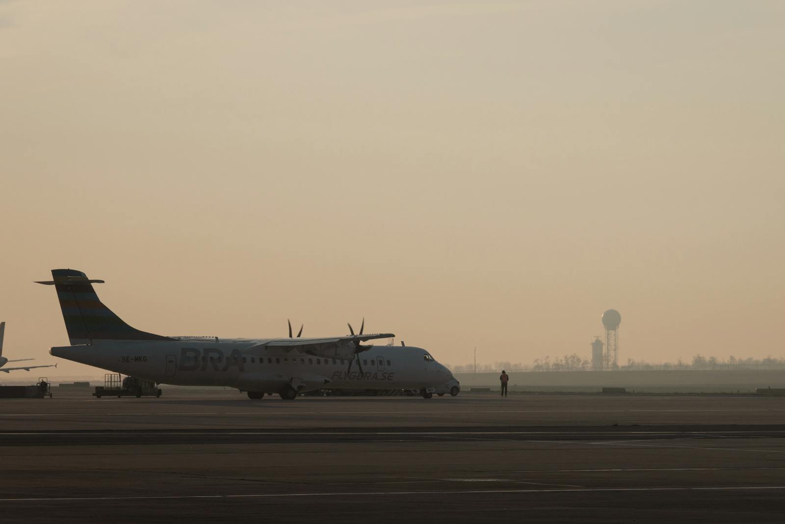 Silhouette of an airplane parked on the runway at sunrise in Schwechat, Austria.