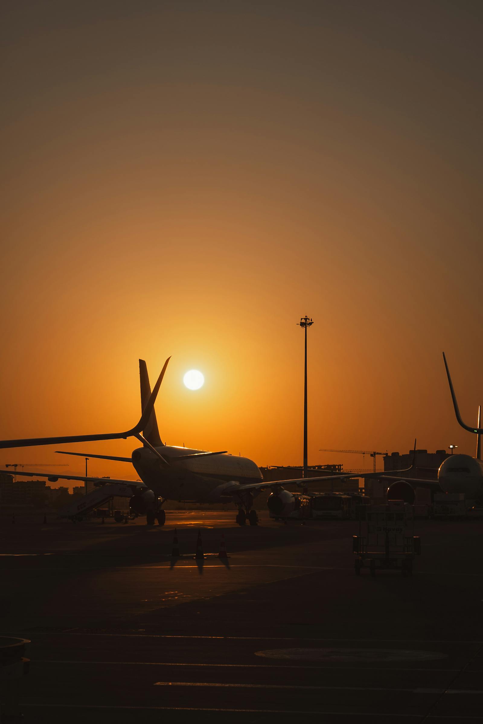 Silhouette of an airplane on the runway during a stunning sunset at Schwechat Airport, Austria.