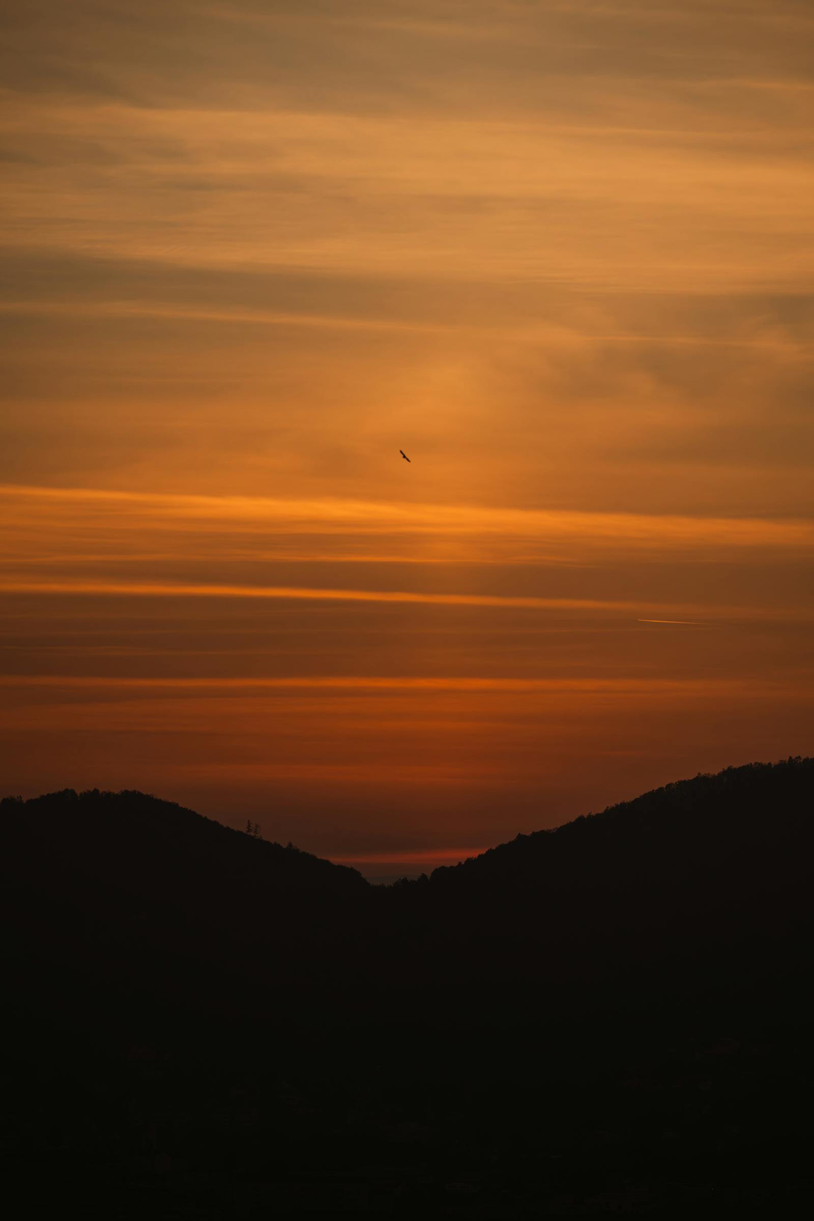 A mesmerizing sunset with golden hues over the Graz mountains, creating a tranquil atmosphere.