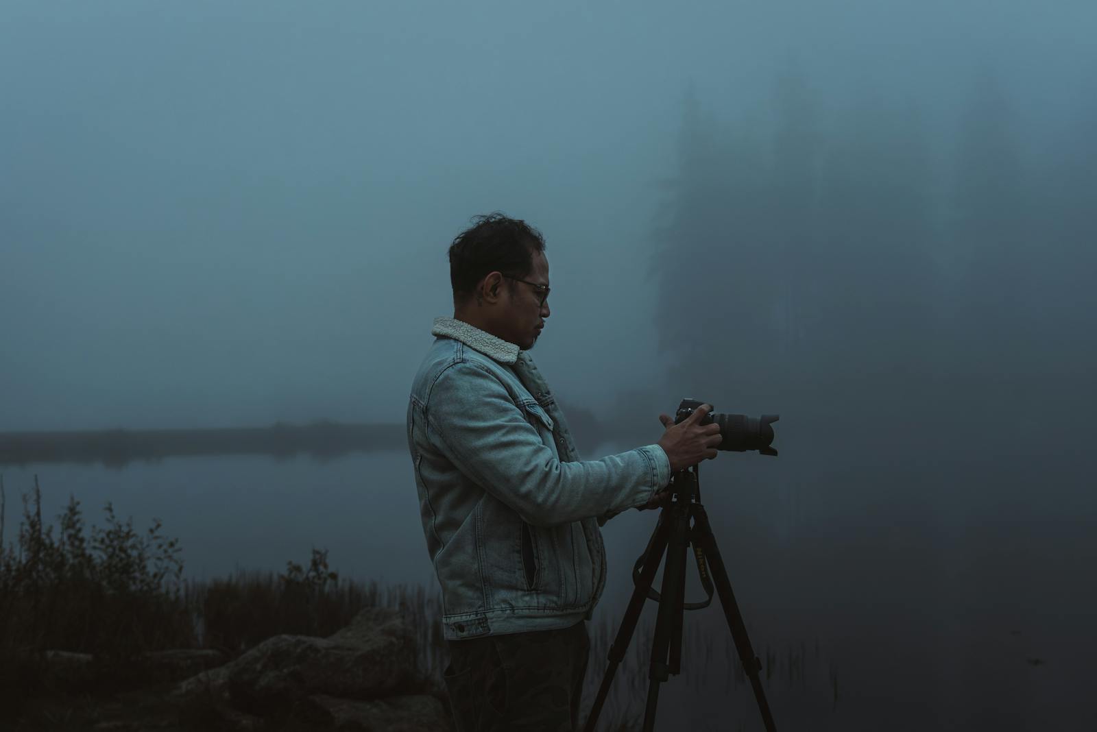 Photographer taking a misty lakeside shot at dawn in Styria, Austria.