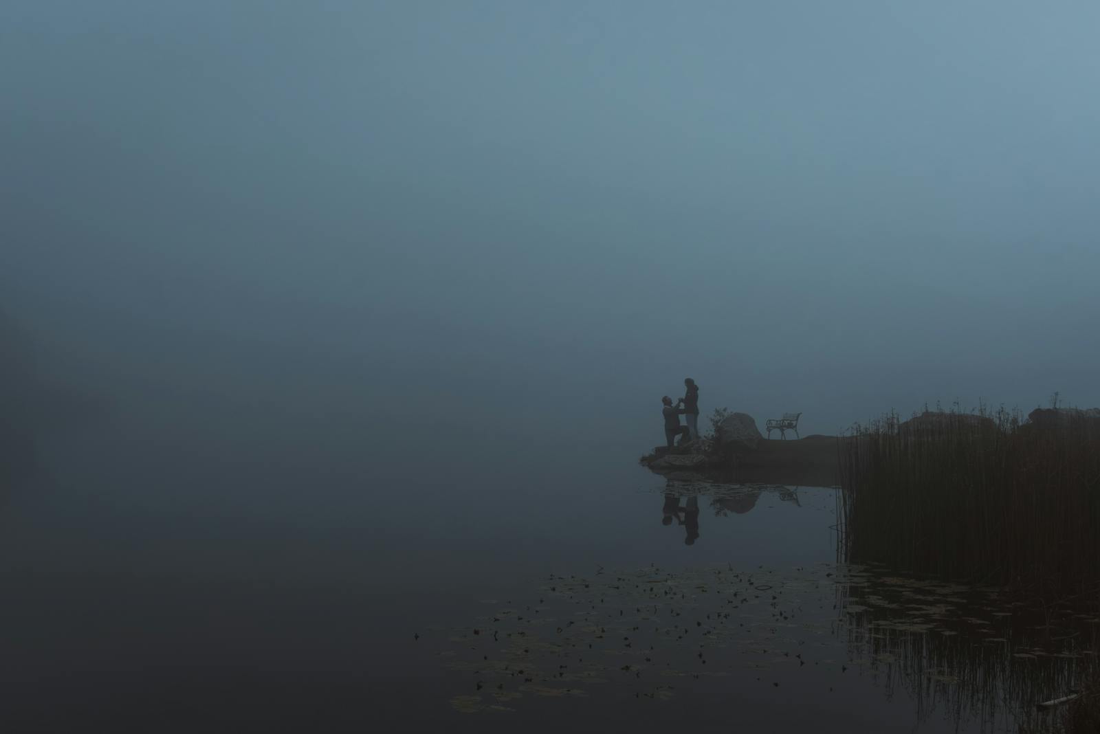 A couple enjoys a misty evening by a serene lake in Styria, Austria.