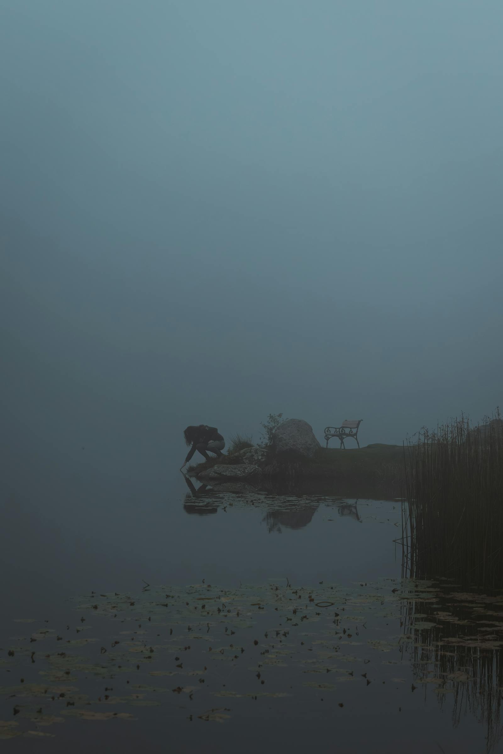 Captivating foggy scene with a solitary bench by the tranquil lake in Styria, Austria.