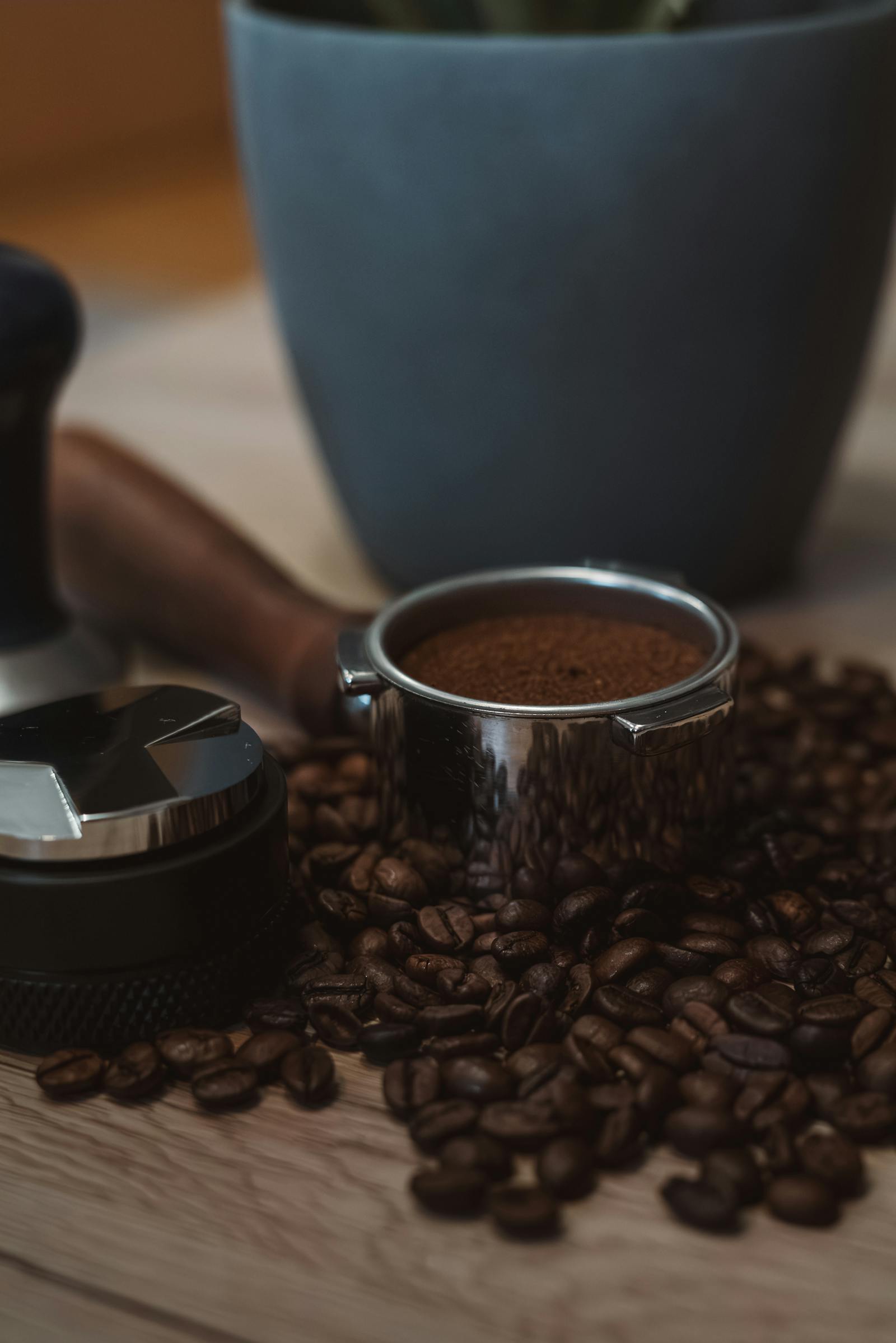 Close-up of espresso tools with coffee beans creating a rich, artisanal vibe in a cozy setting.