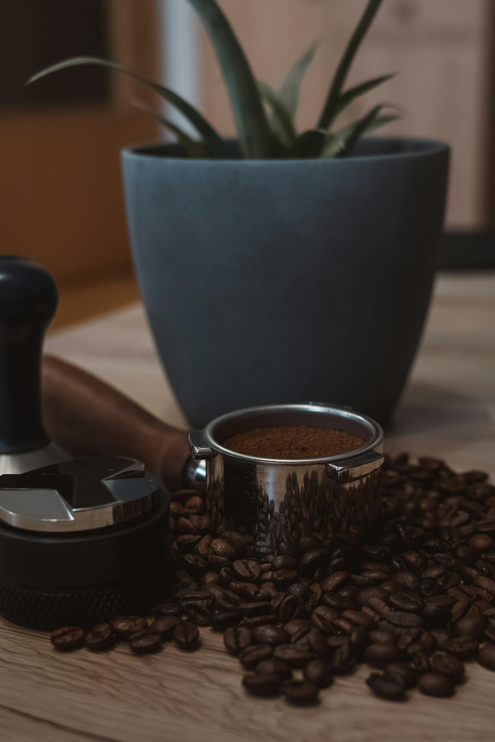 A detailed view of coffee beans and tools for brewing the perfect espresso at home.