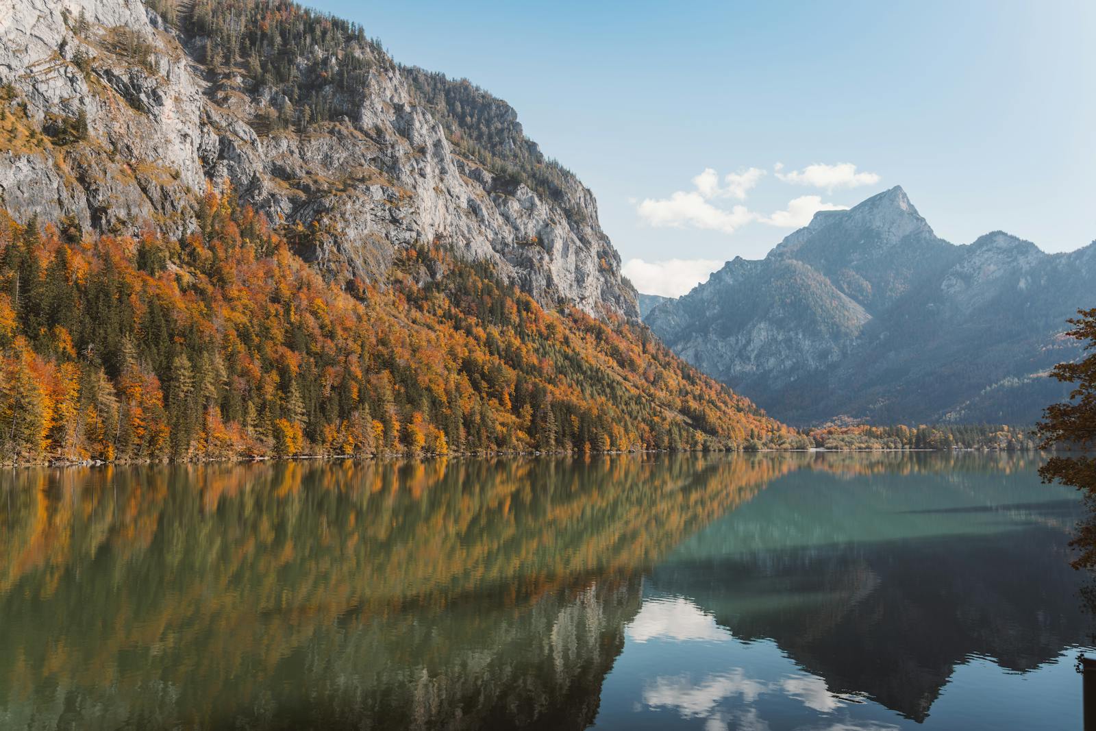 Serene autumn landscape at Eisenerz Lake, Austria, featuring majestic mountain reflections.