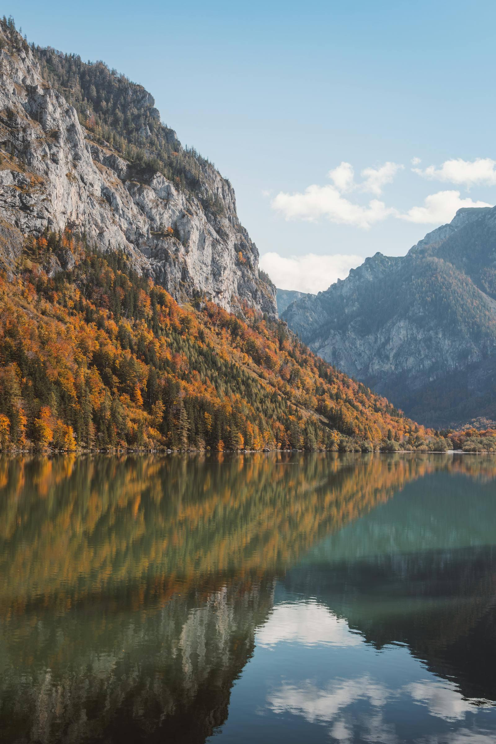 Stunning reflection of autumn foliage on a serene alpine lake in Eisenerz, Austria.