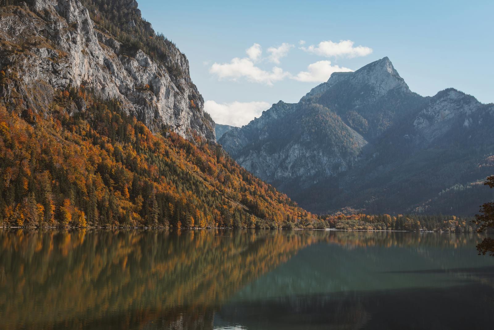 Serene mountain lake reflecting autumn foliage in Eisenerz, Austria.