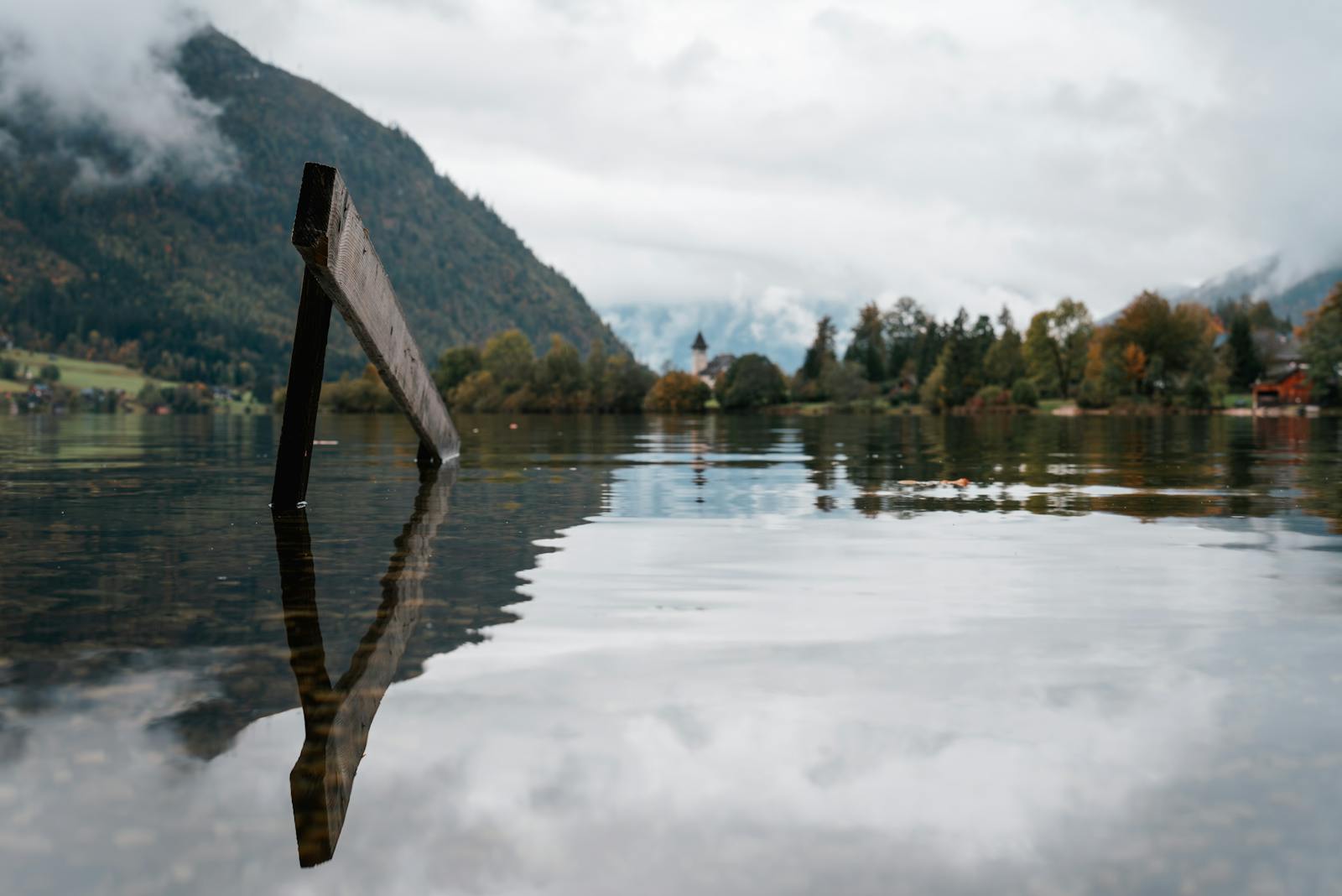 Peaceful autumn lake scene in Austria with mountains and reflection.