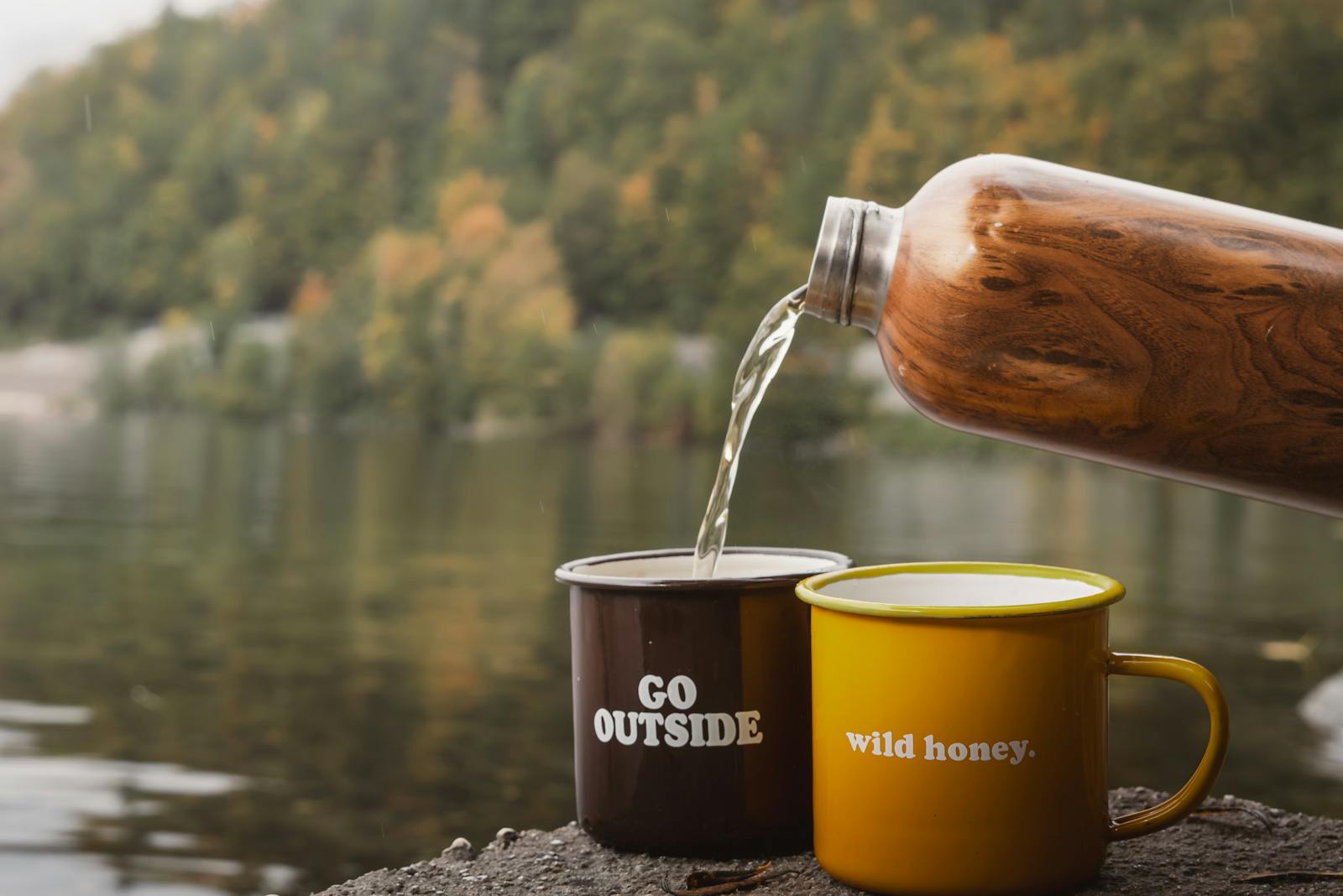 Enjoying a warm coffee moment by the lake with autumn foliage reflections in Bad Aussee, Austria.