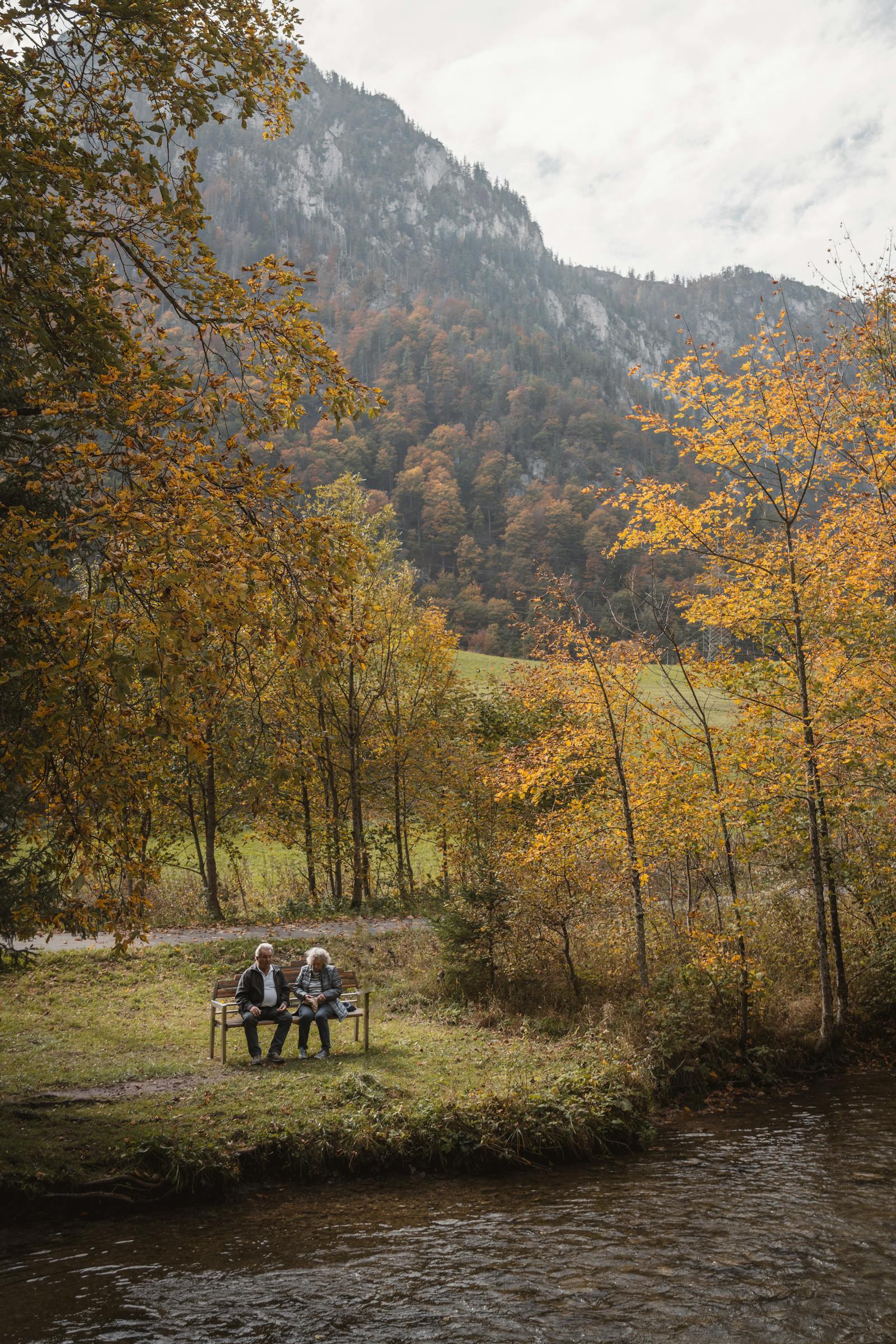 A peaceful riverside picnic in Graz, Austria, surrounded by vibrant autumn foliage.