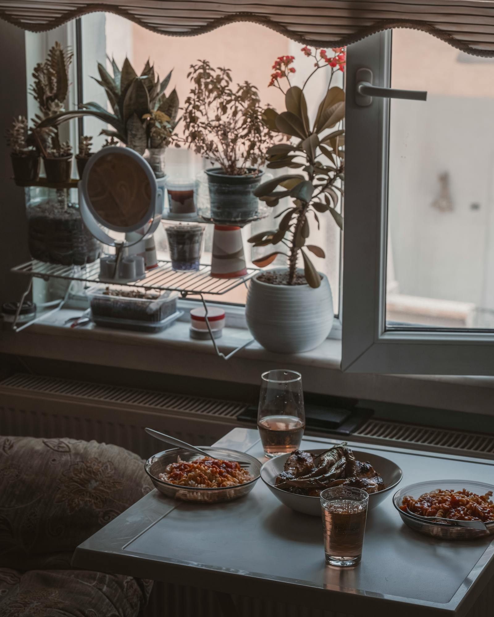 A serene indoor lunch setup by the window with plants and minimalist decor.