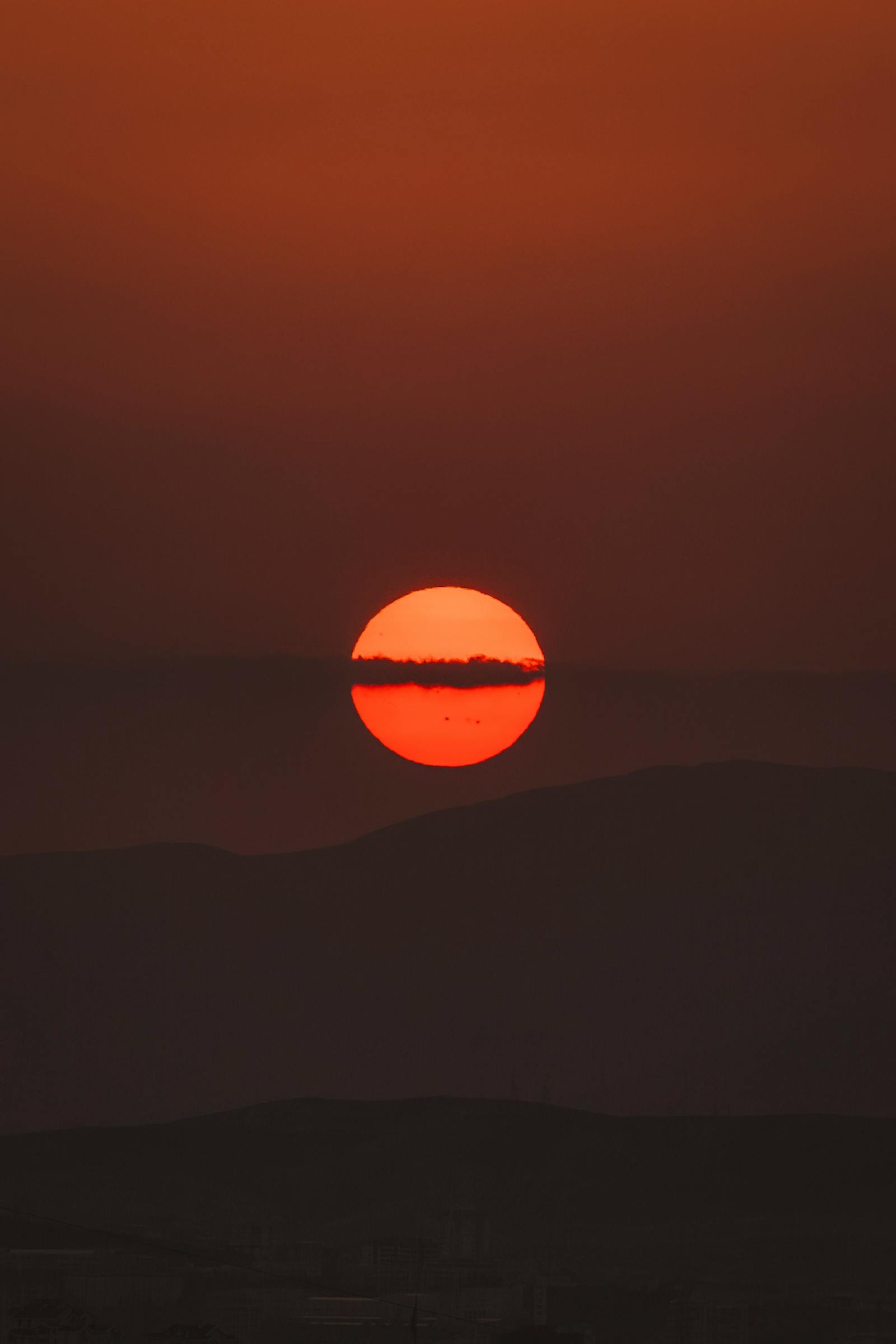 Captivating view of the sun setting over Ankara, casting a warm glow across the horizon.