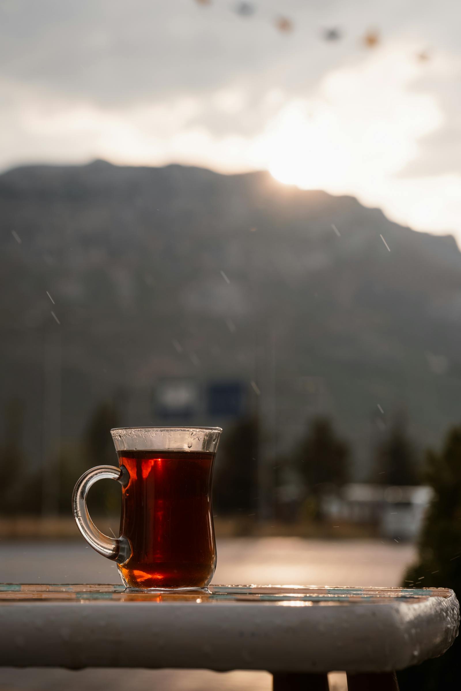 Peaceful tea moment with a misty mountain backdrop at sunrise in Seydişehir, Türkiye.