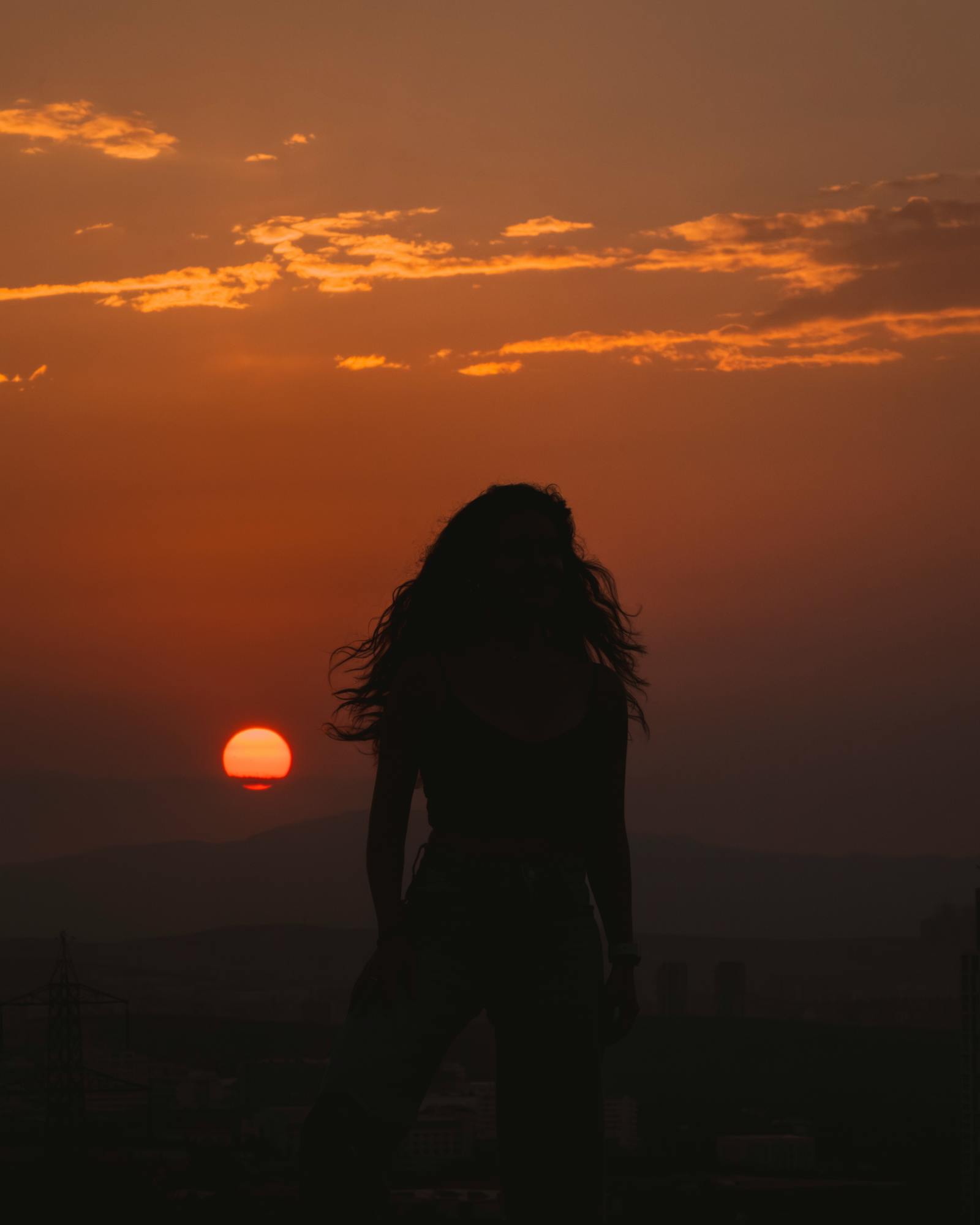 Silhouette of a woman during sunset in Ankara, capturing a serene and dramatic evening sky.