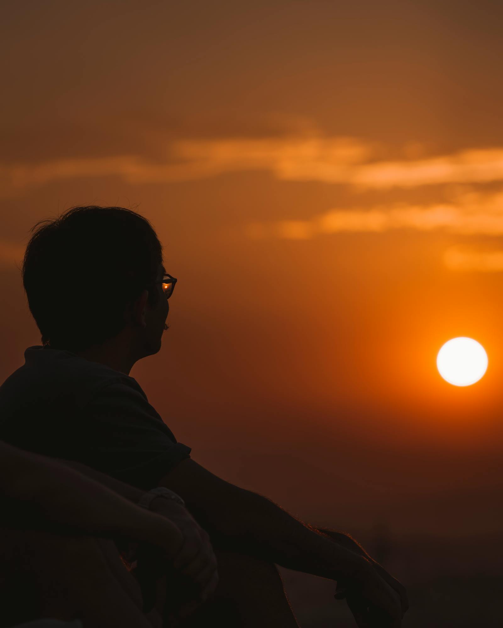 A man gazes at the sunset in Ankara, Türkiye, capturing a serene moment of solitude.