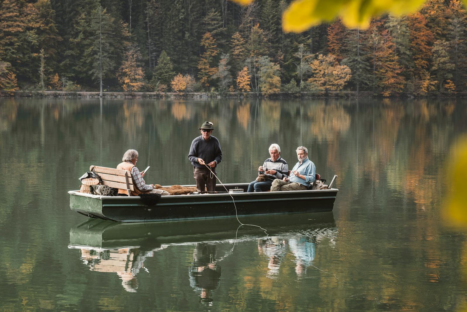 A tranquil group of seniors fishing on a boat in Graz, surrounded by autumn foliage.