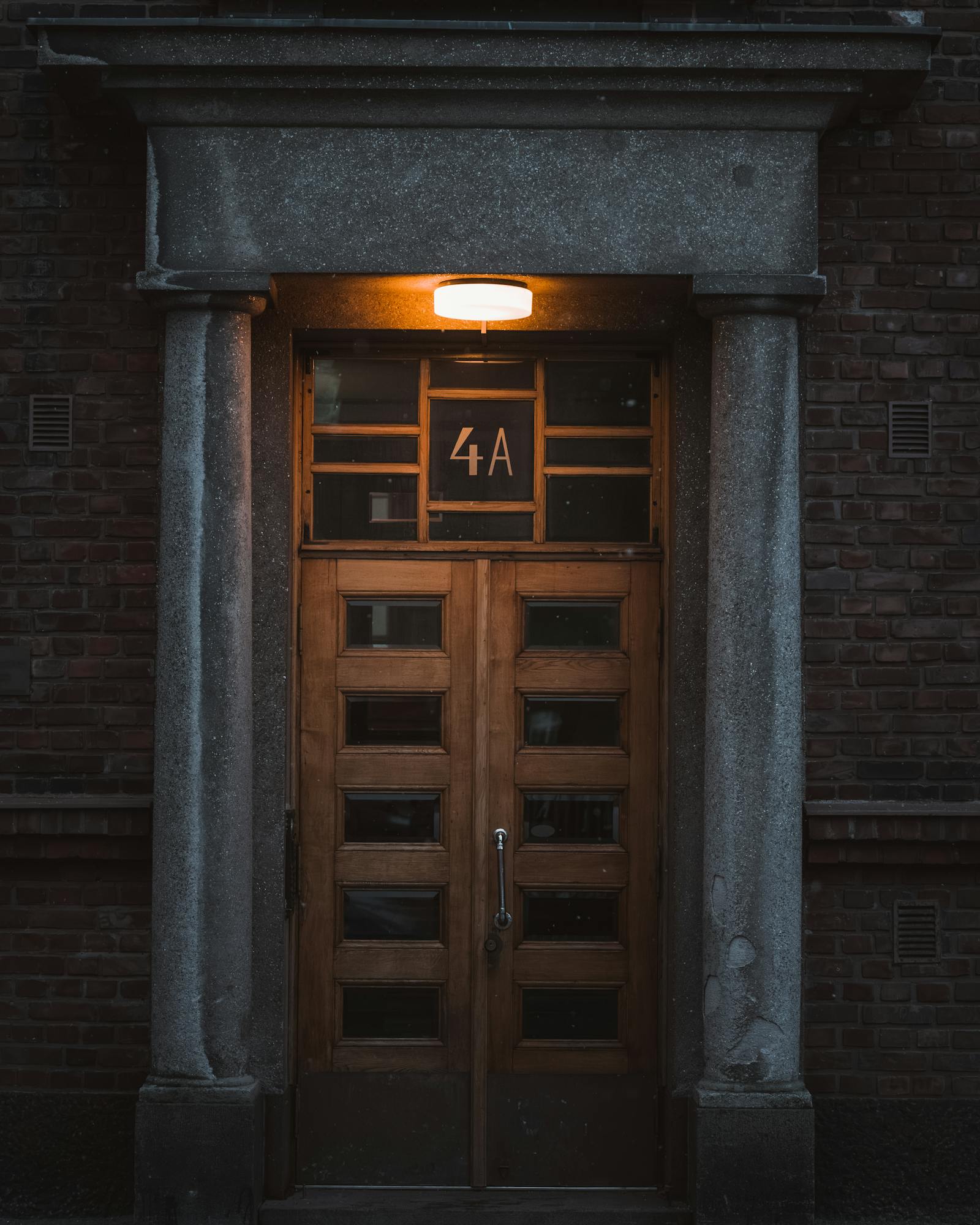 Cozy entrance at night with glowing porch light highlighting a wooden door in Turku, Finland.