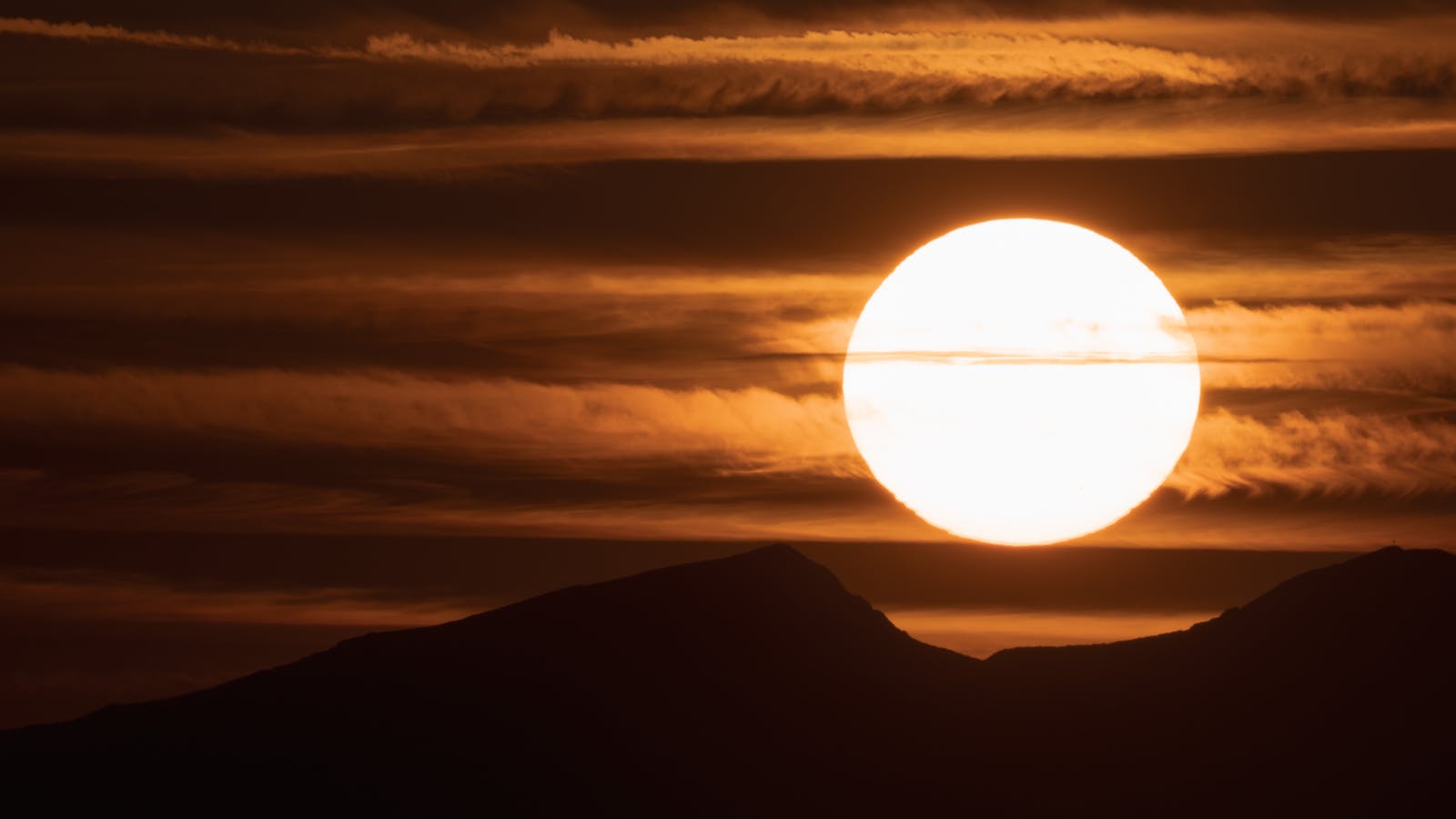 A stunning sunset over the mountains of Wildschönau in Tyrol, Austria, with vivid colors and silhouettes.