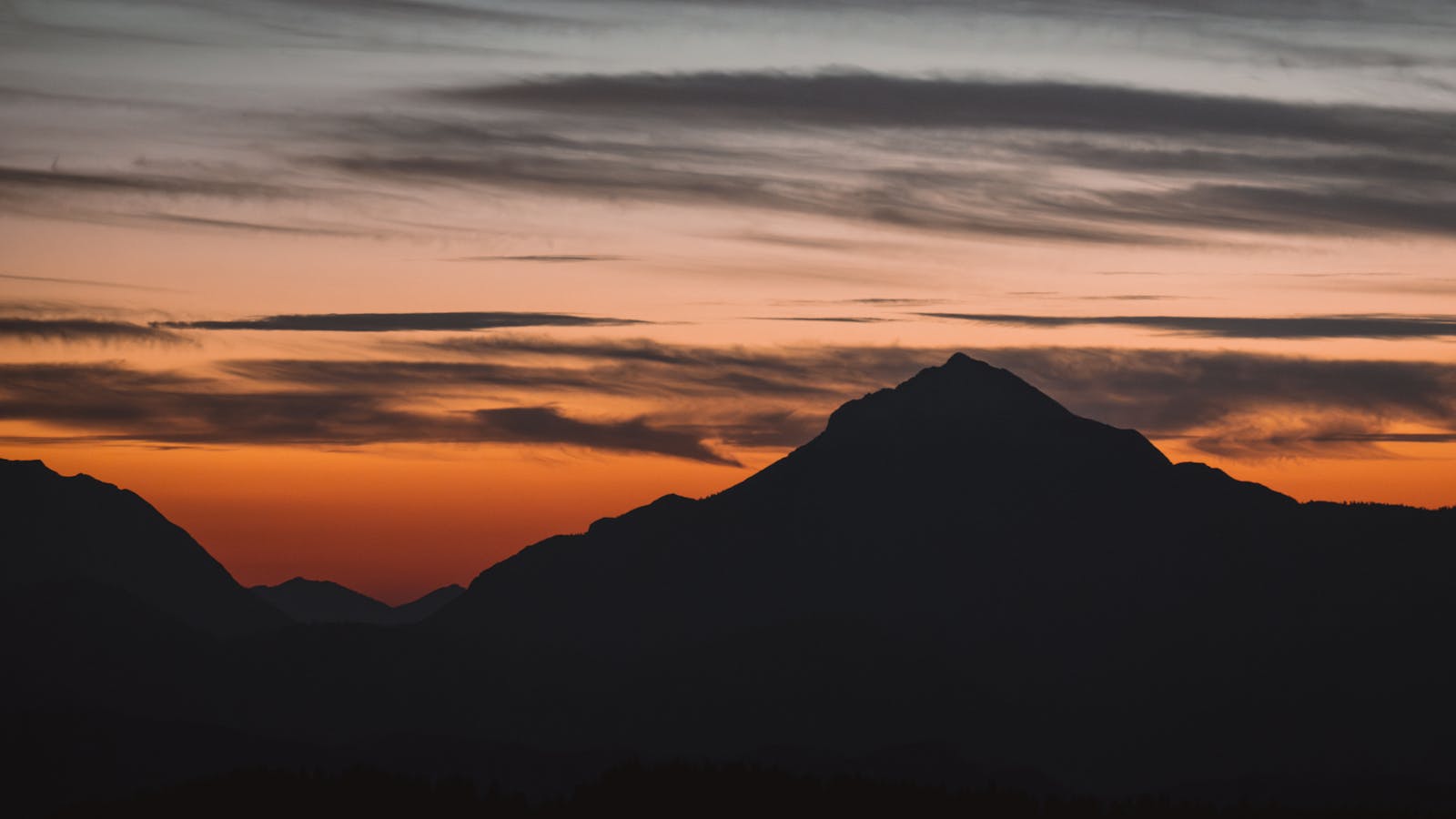 Beautiful sunset view with mountain silhouette in Innsbruck, Austria, capturing a peaceful and scenic atmosphere.