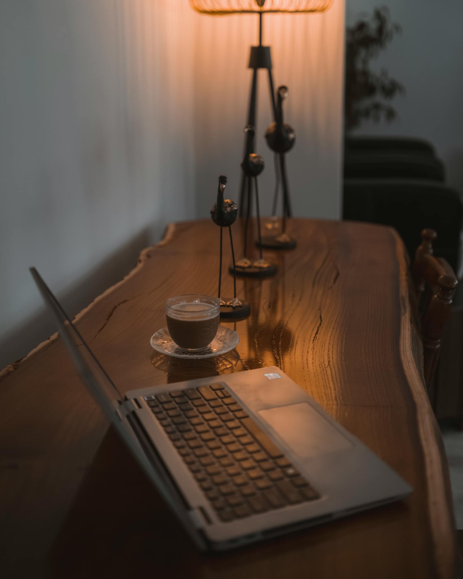 Warm home office setup with coffee on a wooden desk, perfect for productivity.