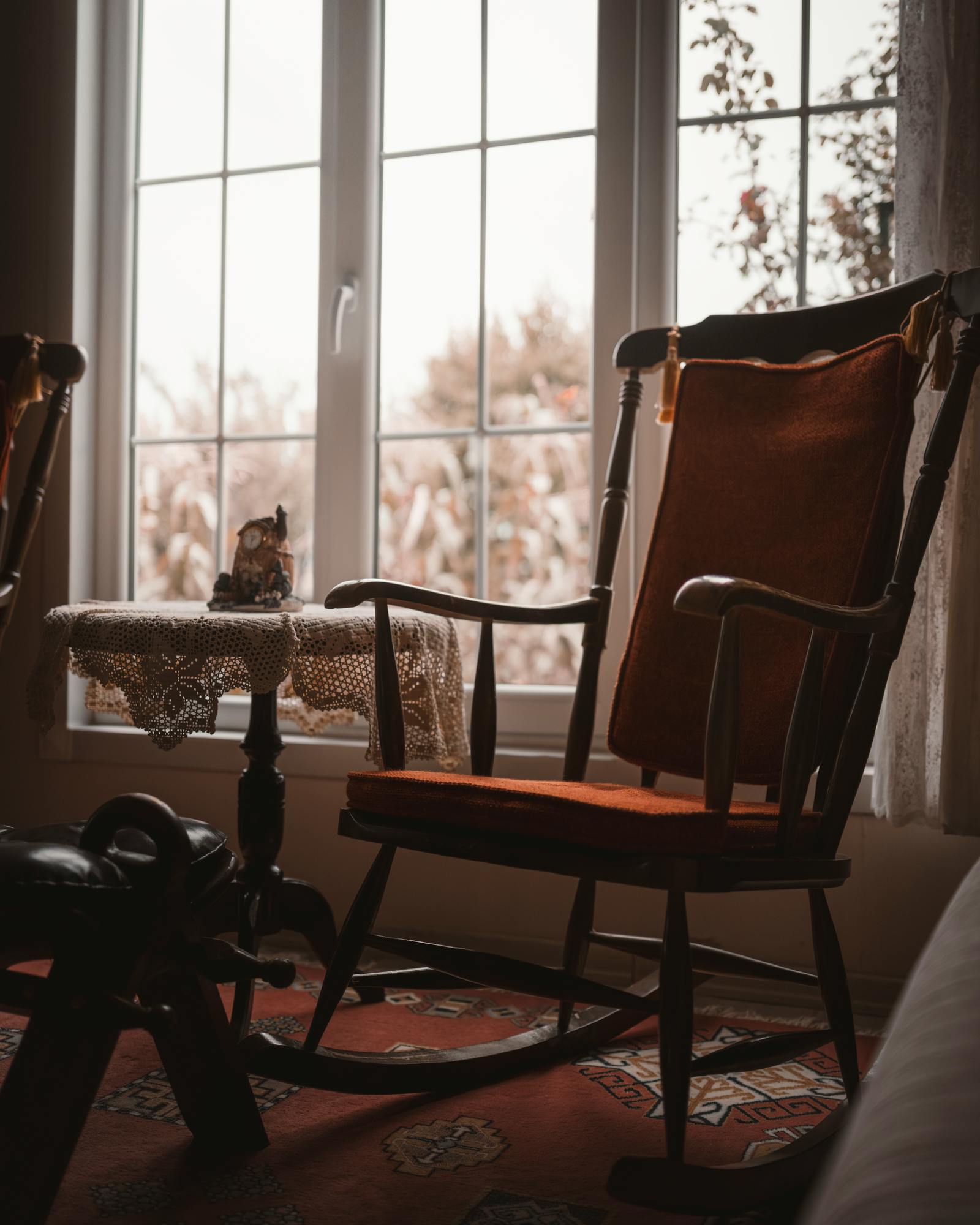 A peaceful vintage living room corner with a rocking chair by a sunny window.