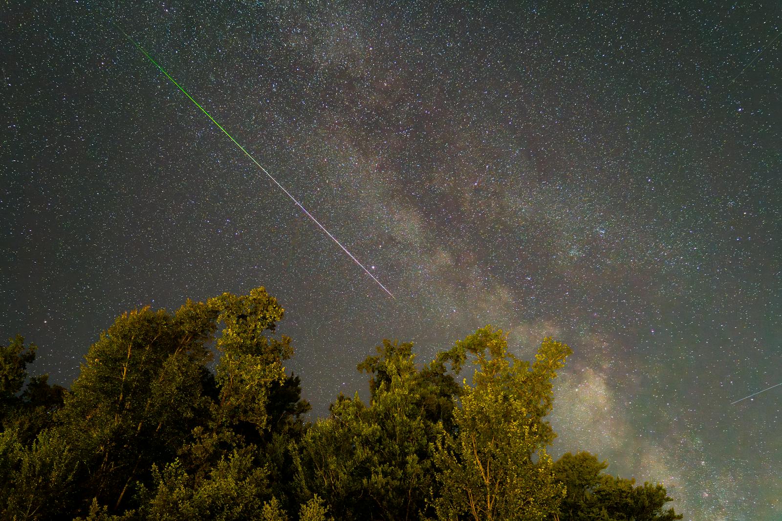 Stunning night sky in Graz, Austria featuring a meteor shower and the Milky Way.