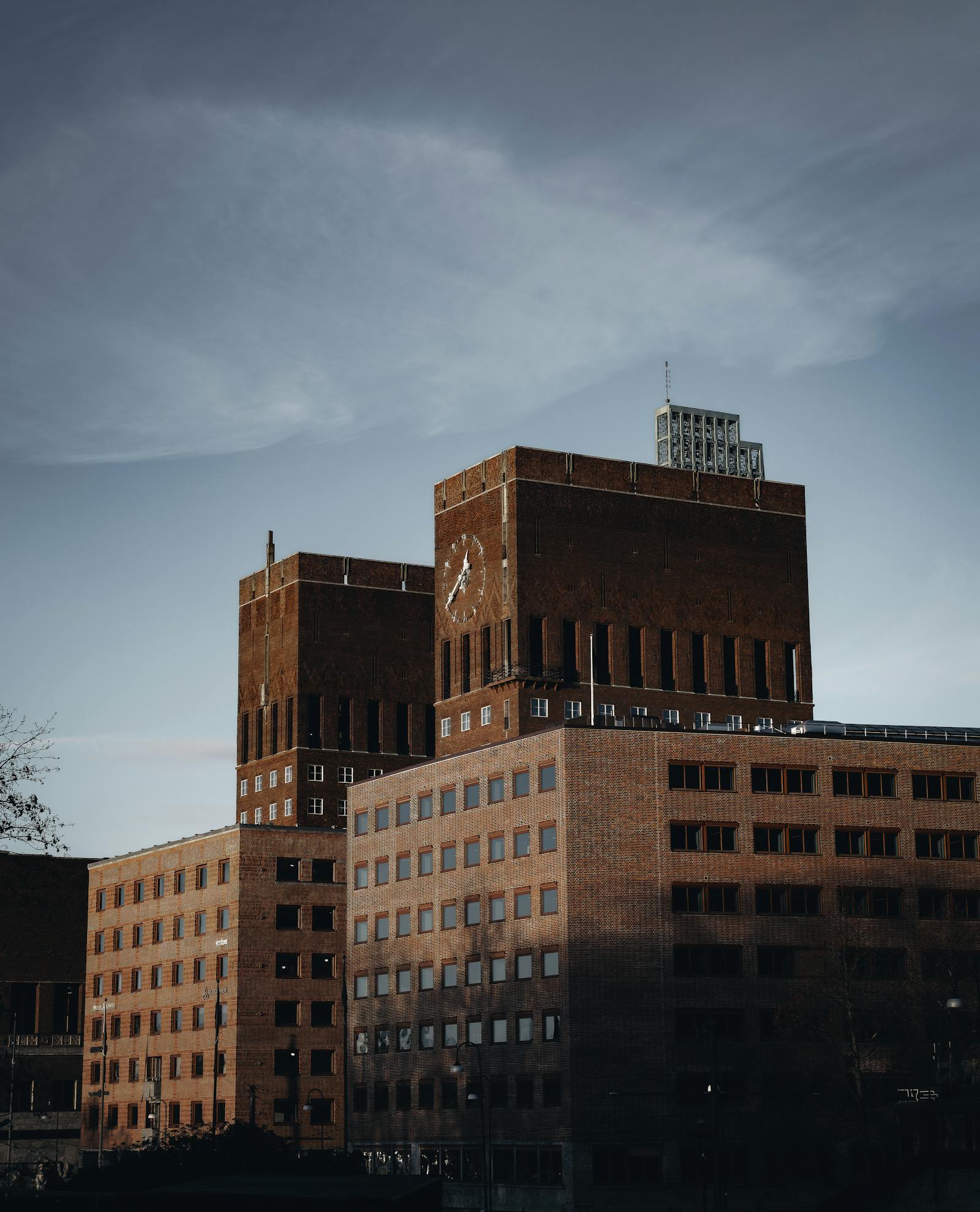 View of the Oslo City Hall, showcasing its architectural design under a soft evening light.