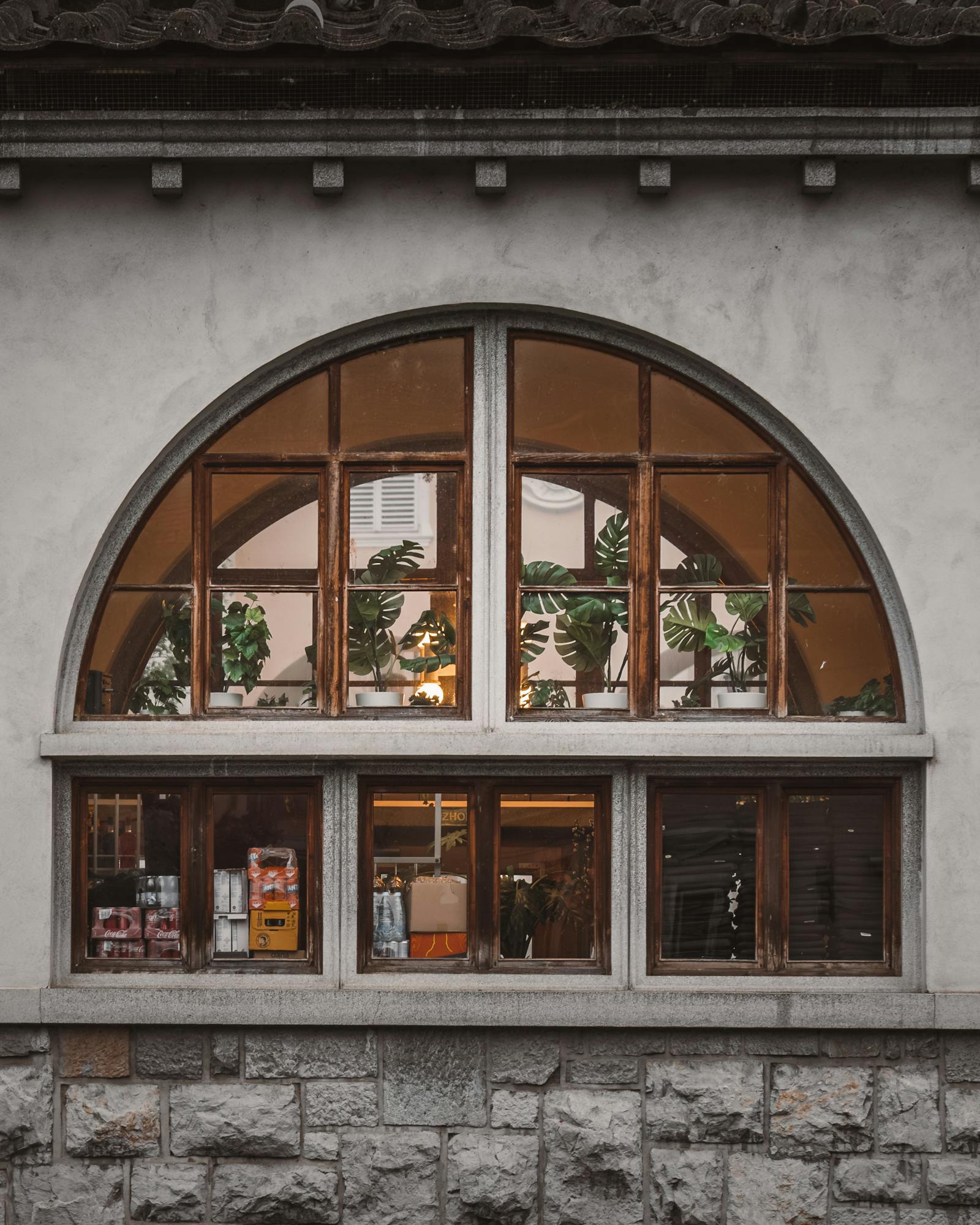 Exterior view of a cozy cafe through a vintage arched window in Ljubljana, Slovenia.