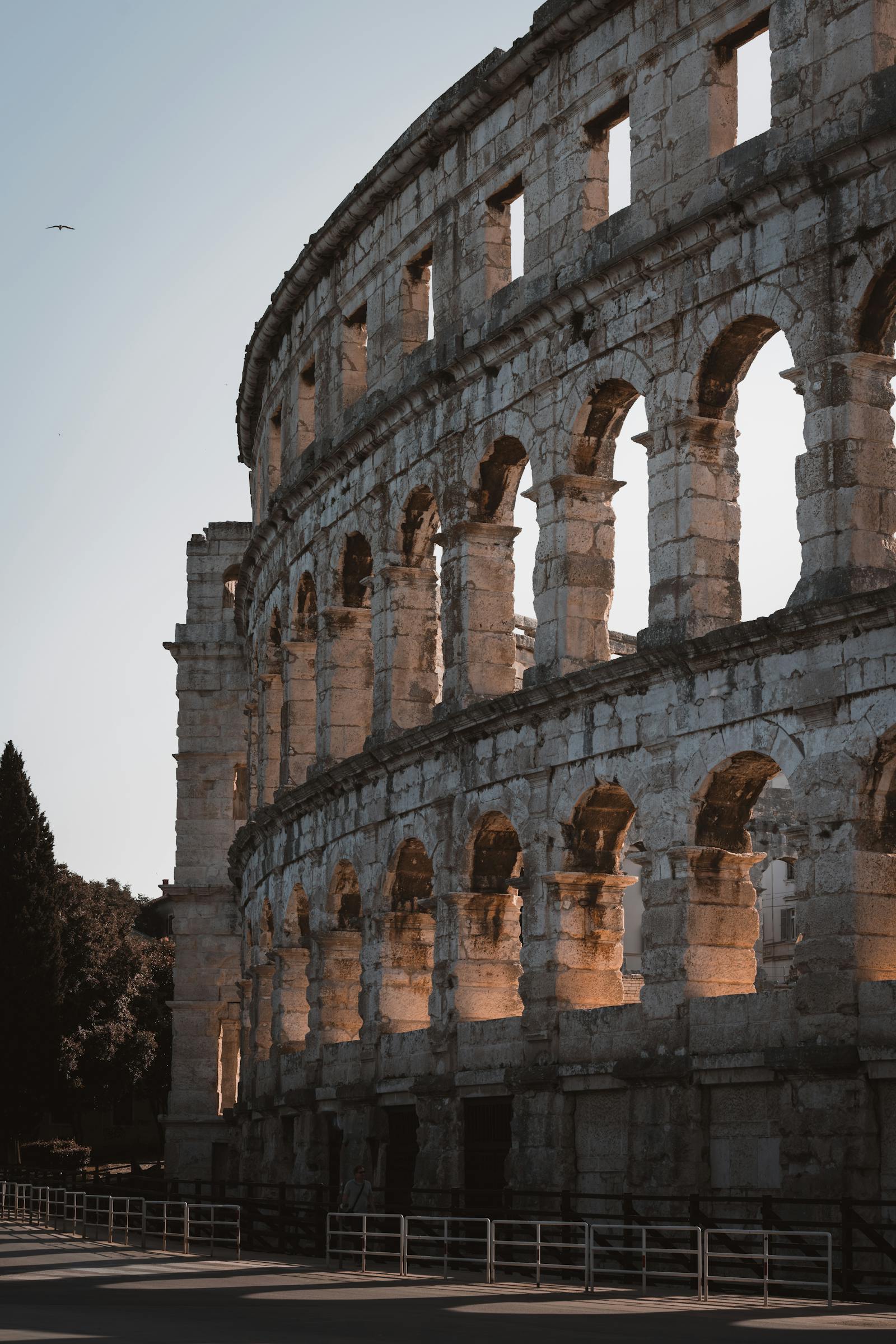 Capture the historic beauty of the ancient Roman amphitheater in Pula at sunset.