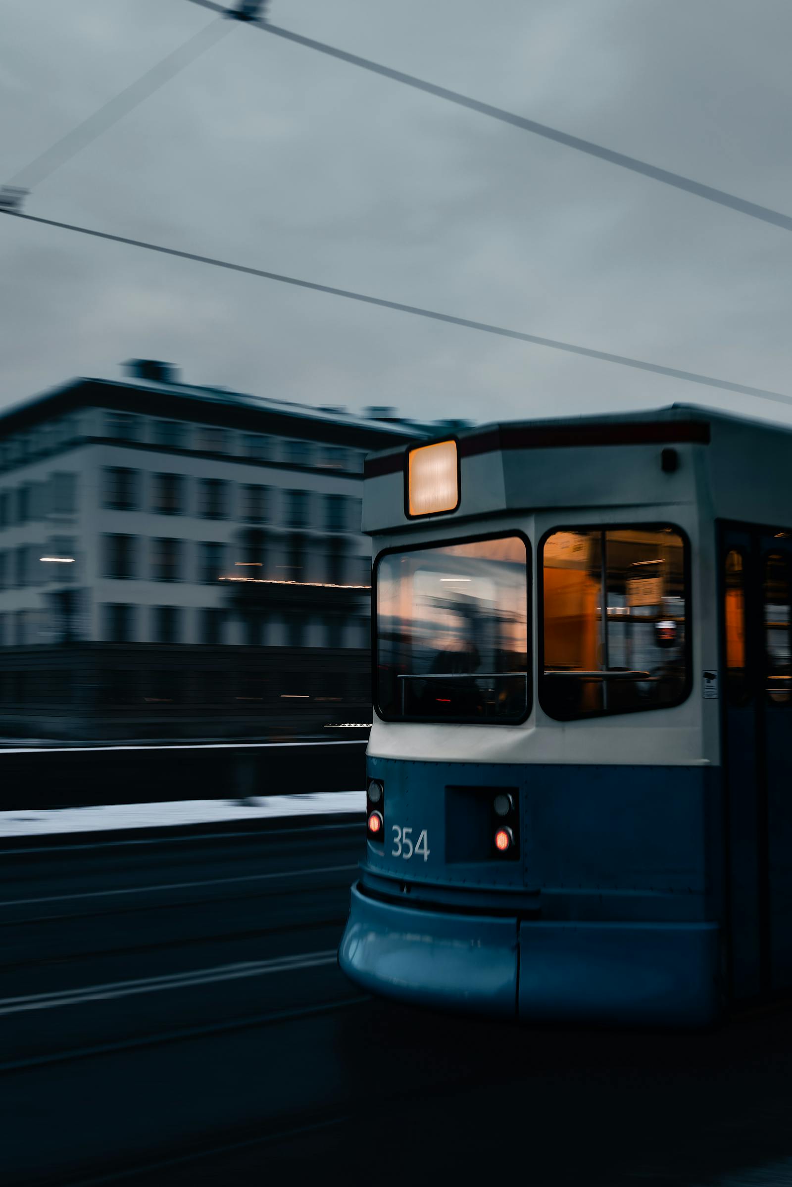 Dynamic photo of a moving tram during twilight in Oslo, capturing urban transit energy.