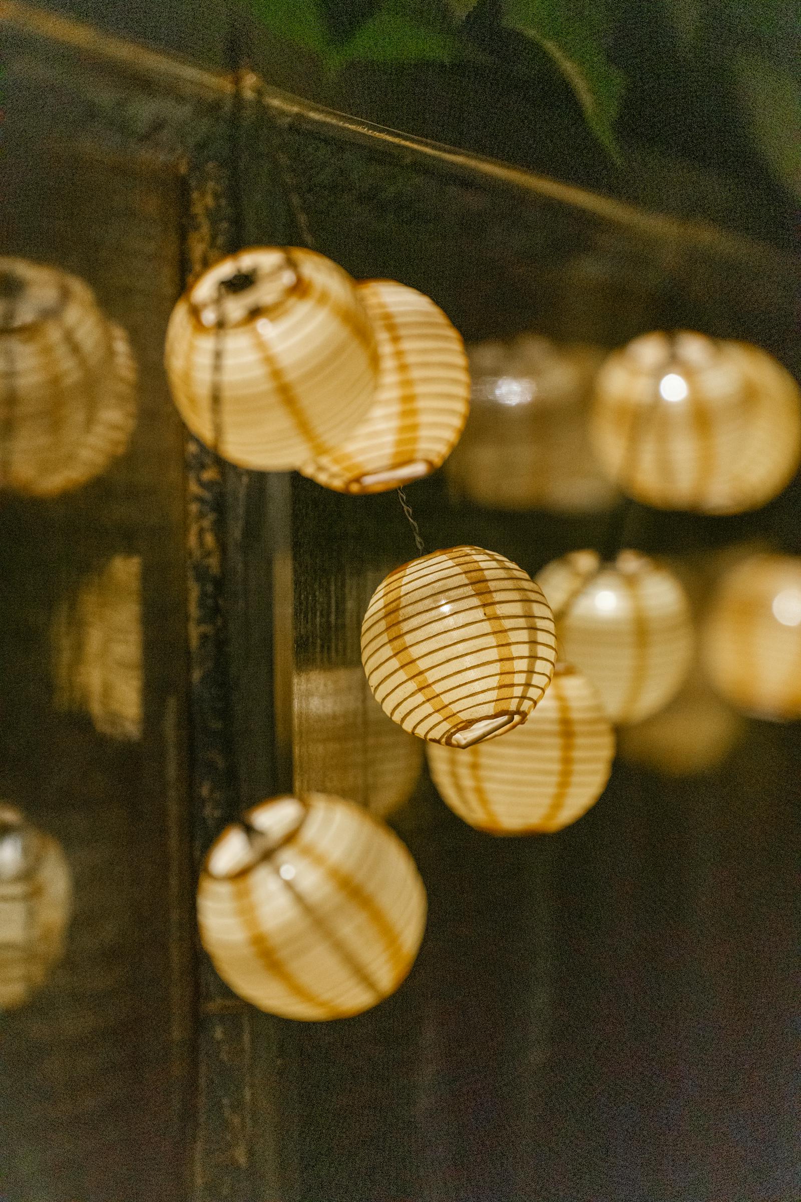 A close-up of warmly lit hanging lanterns creating an inviting atmosphere indoors.