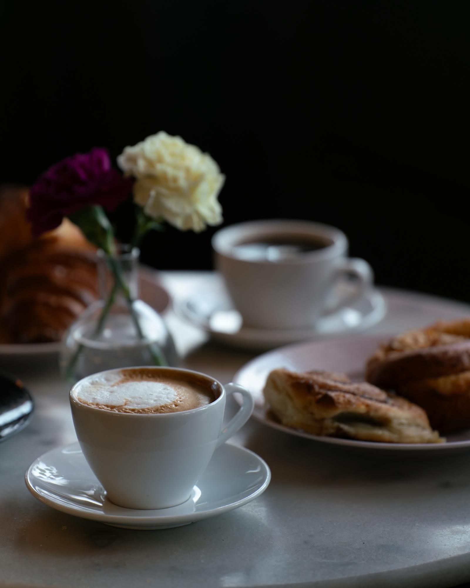 Enjoy a warm cappuccino and pastry in Stockholm's cozy cafe setting. Perfect for coffee lovers.