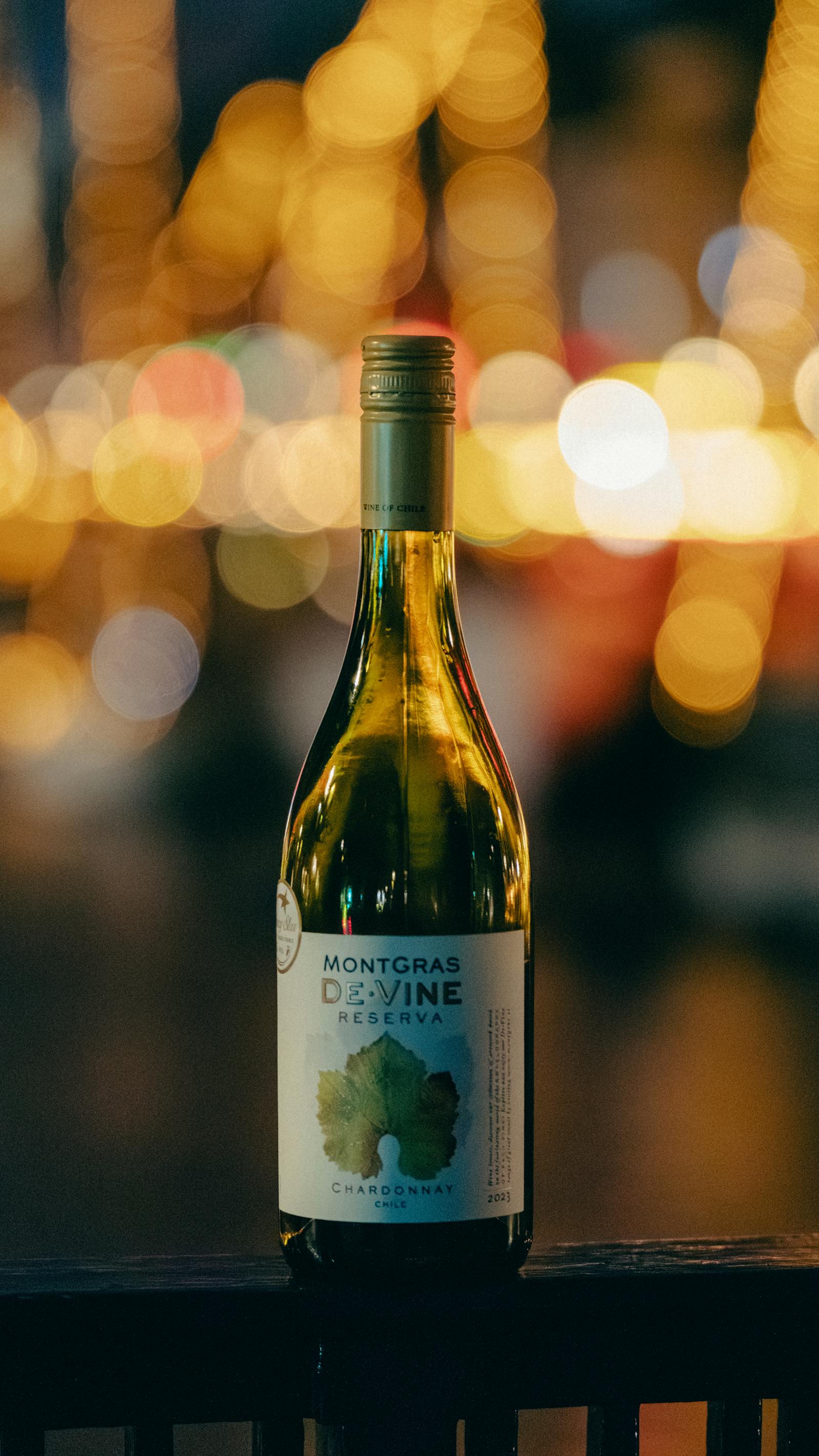 Chardonnay wine bottle set against blurred evening city lights, Copenhagen.