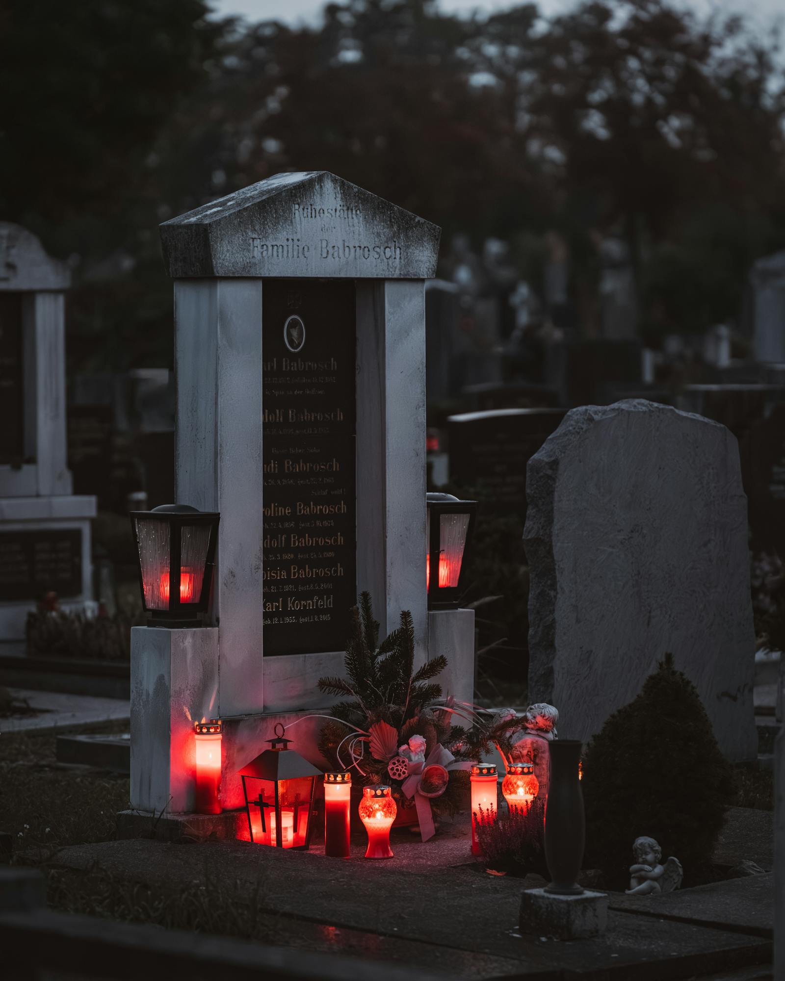 Peaceful cemetery view in Vienna, Austria with glowing candles at sunset, creating a warm aura.