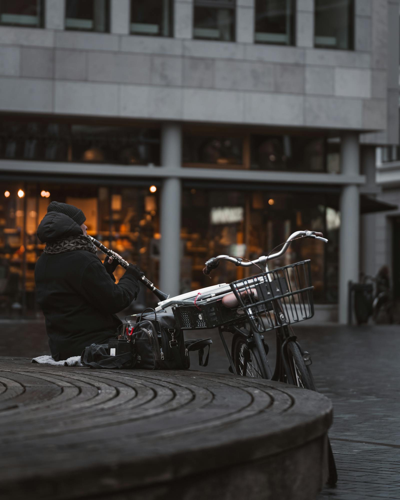 A street musician plays the flute in a Copenhagen city square, adding charm to the urban atmosphere.