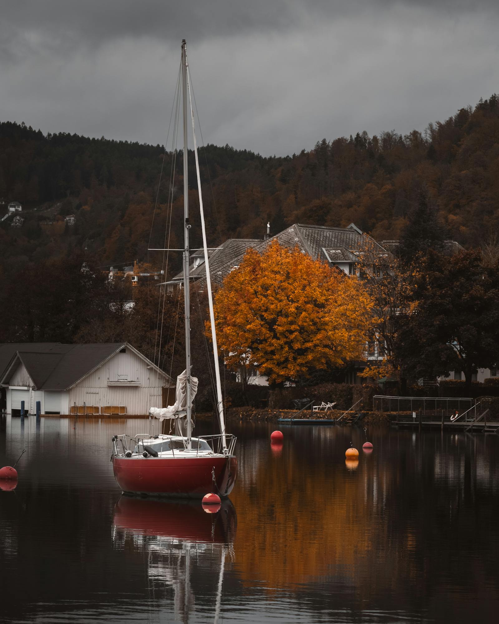 Tranquil scene of a sailboat in autumn at Pörtschach am Wörthersee, Austria.