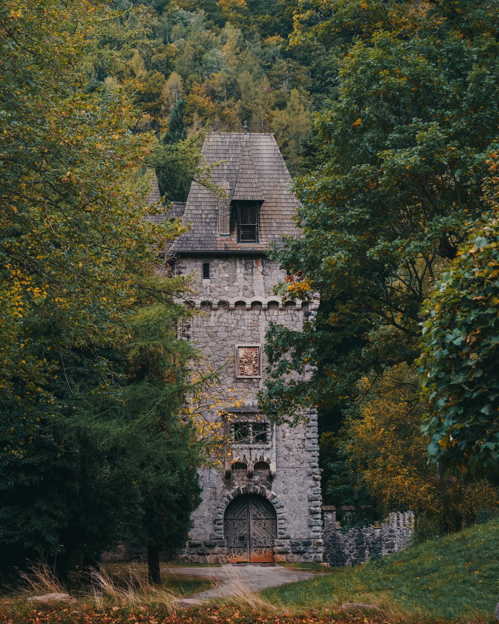 Discover the enchanting medieval tower in Eisenerz, Austria, surrounded by lush autumn forest.