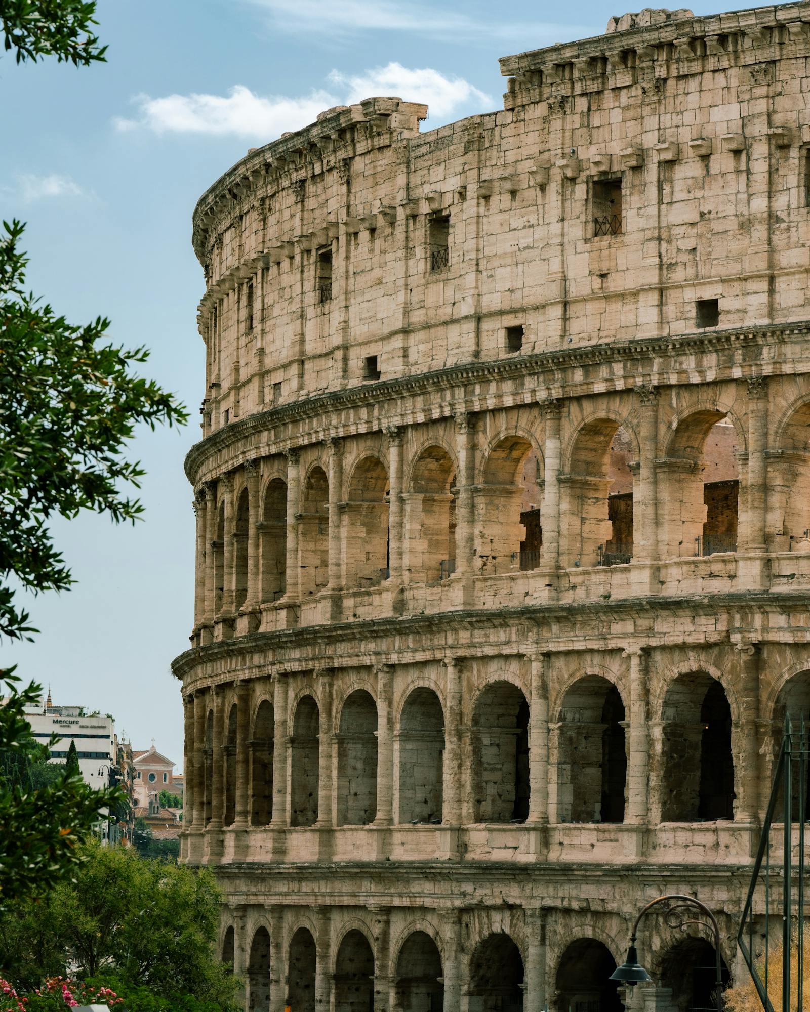 A stunning view of the Colosseum against a clear sky, showcasing its ancient architecture in Rome, Italy.