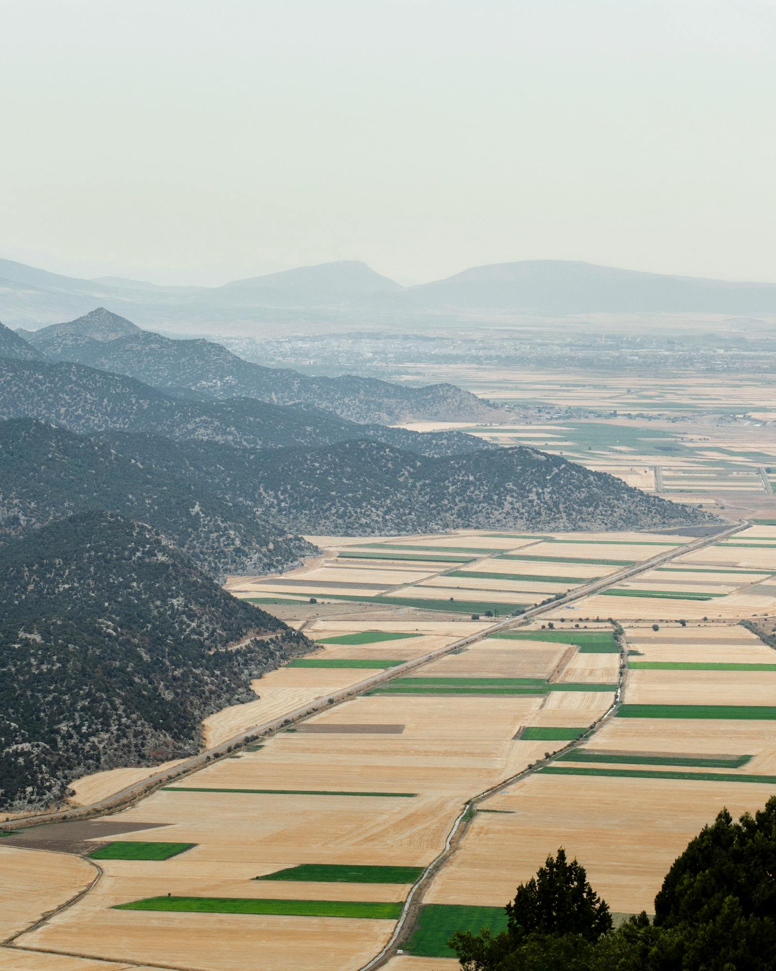 A sweeping aerial view showcasing the patchwork fields and hills of Seydişehir, Konya, Türkiye.