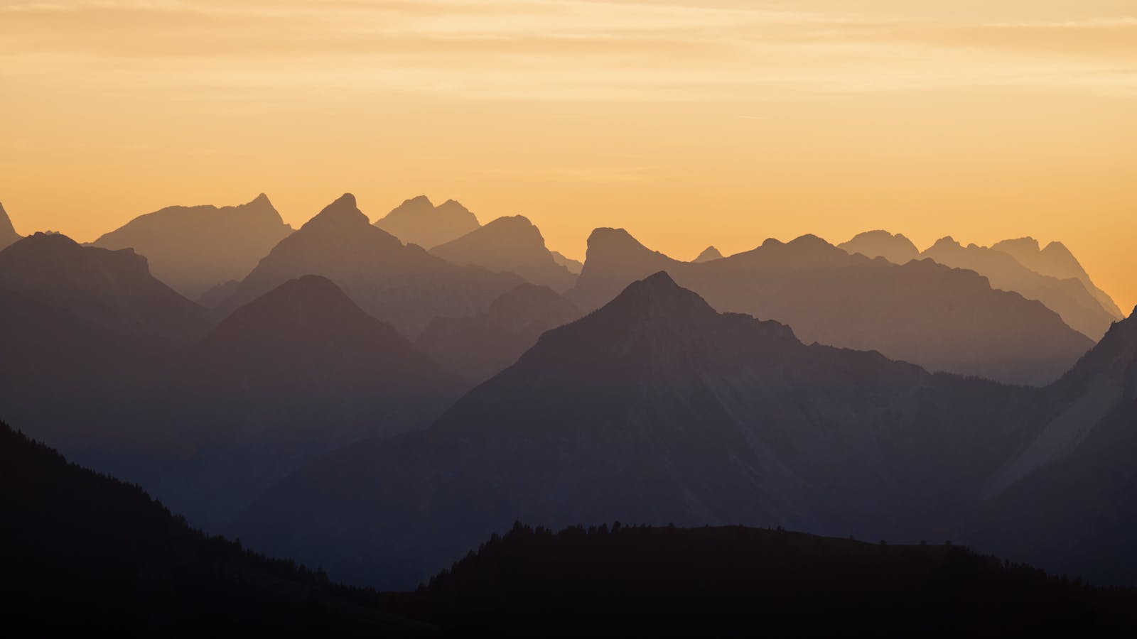 Beautiful silhouette of mountain peaks in Tyrol, Austria at sunset.