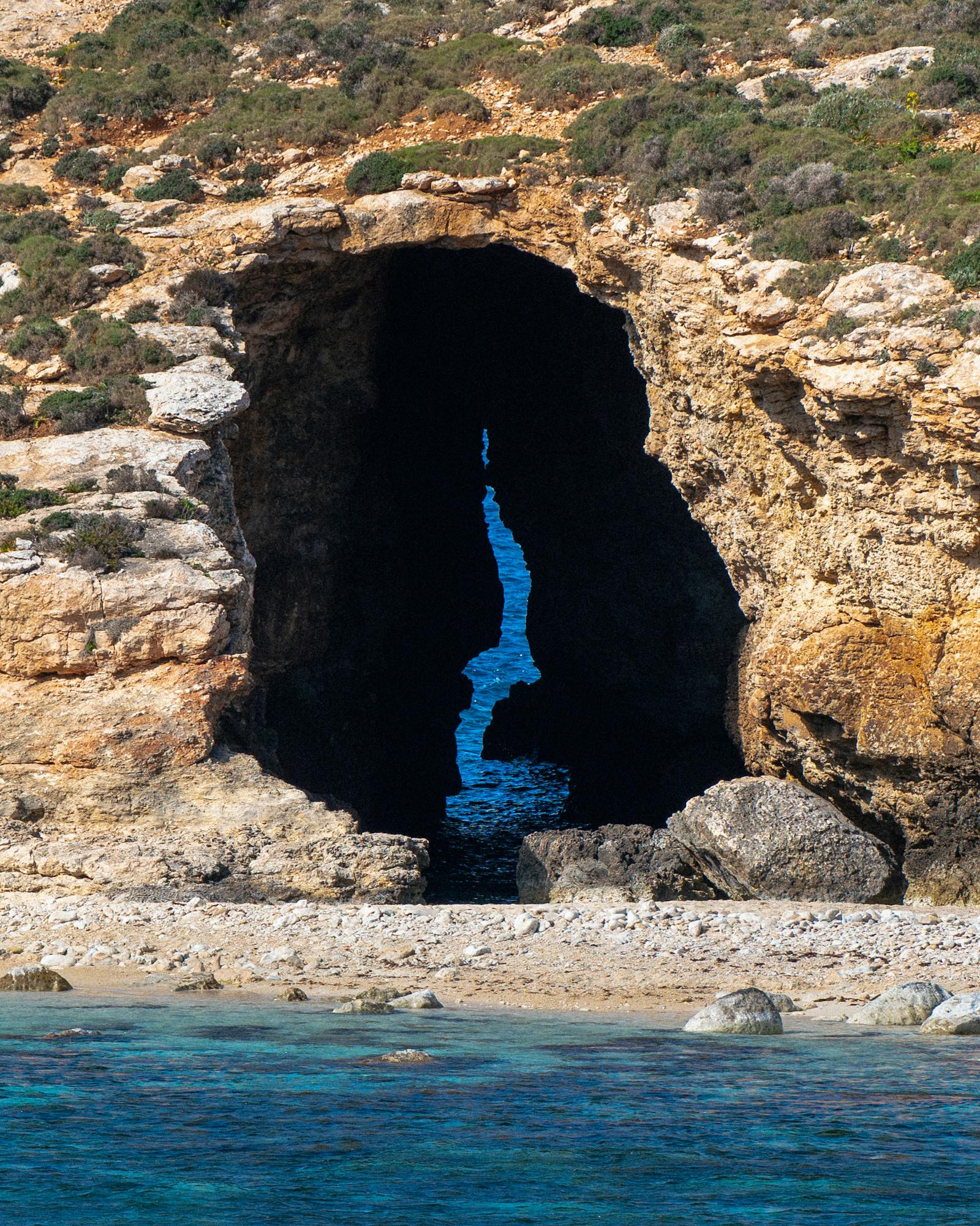 Captivating view of a sea cave on the Maltese coast with bright blue waters highlighting the archway.