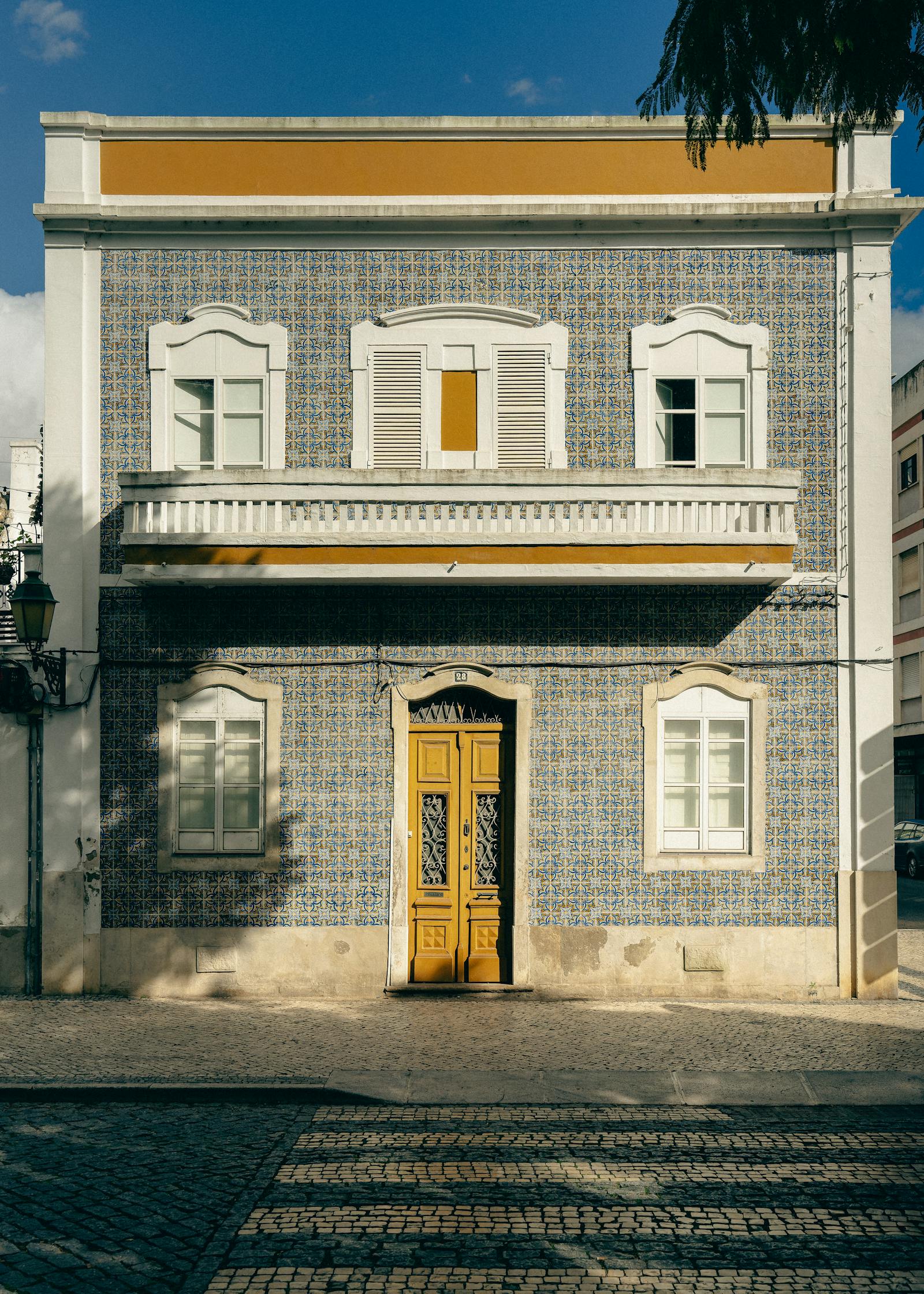 Colorful facade of a traditional Portuguese building with decorative tiles and yellow accents.